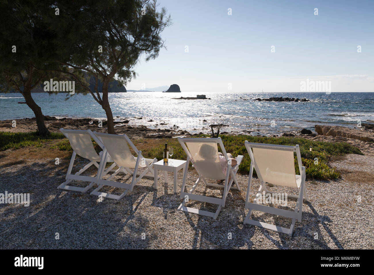 Liegestühle mit Blick auf den Sonnenuntergang am Nefeli Sunset Studios, Pollonia, Milos, Kykladen, Ägäis, Griechische Inseln; Griechenland; Europa Stockfoto