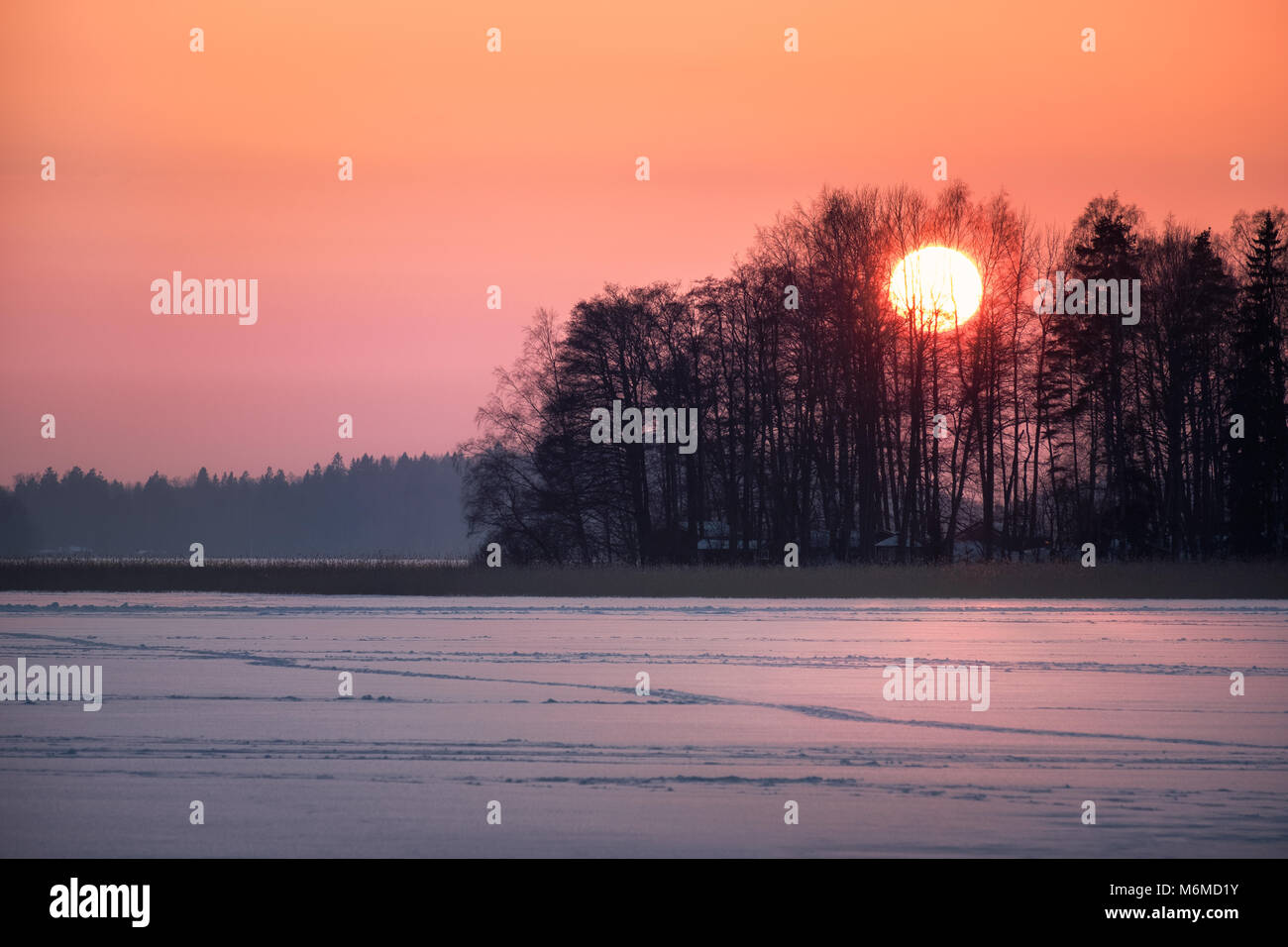 Einen malerischen Sonnenuntergang mit großen Sonne im Winter abends in Finnland Stockfoto