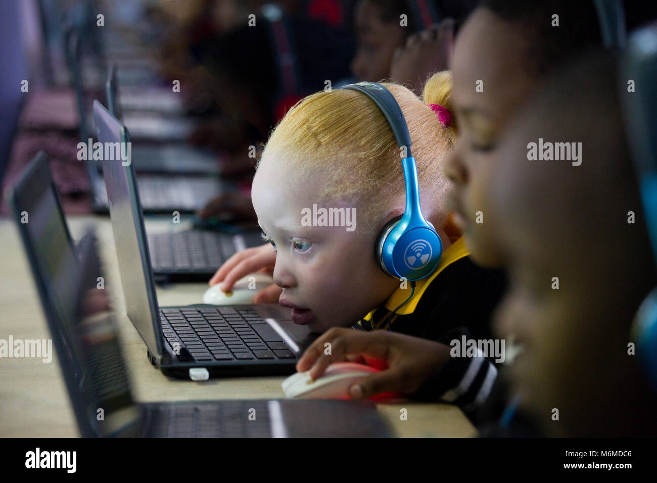 Schule Mädchen Kind sitzen und konzentriert an einem Laptop Stockfoto