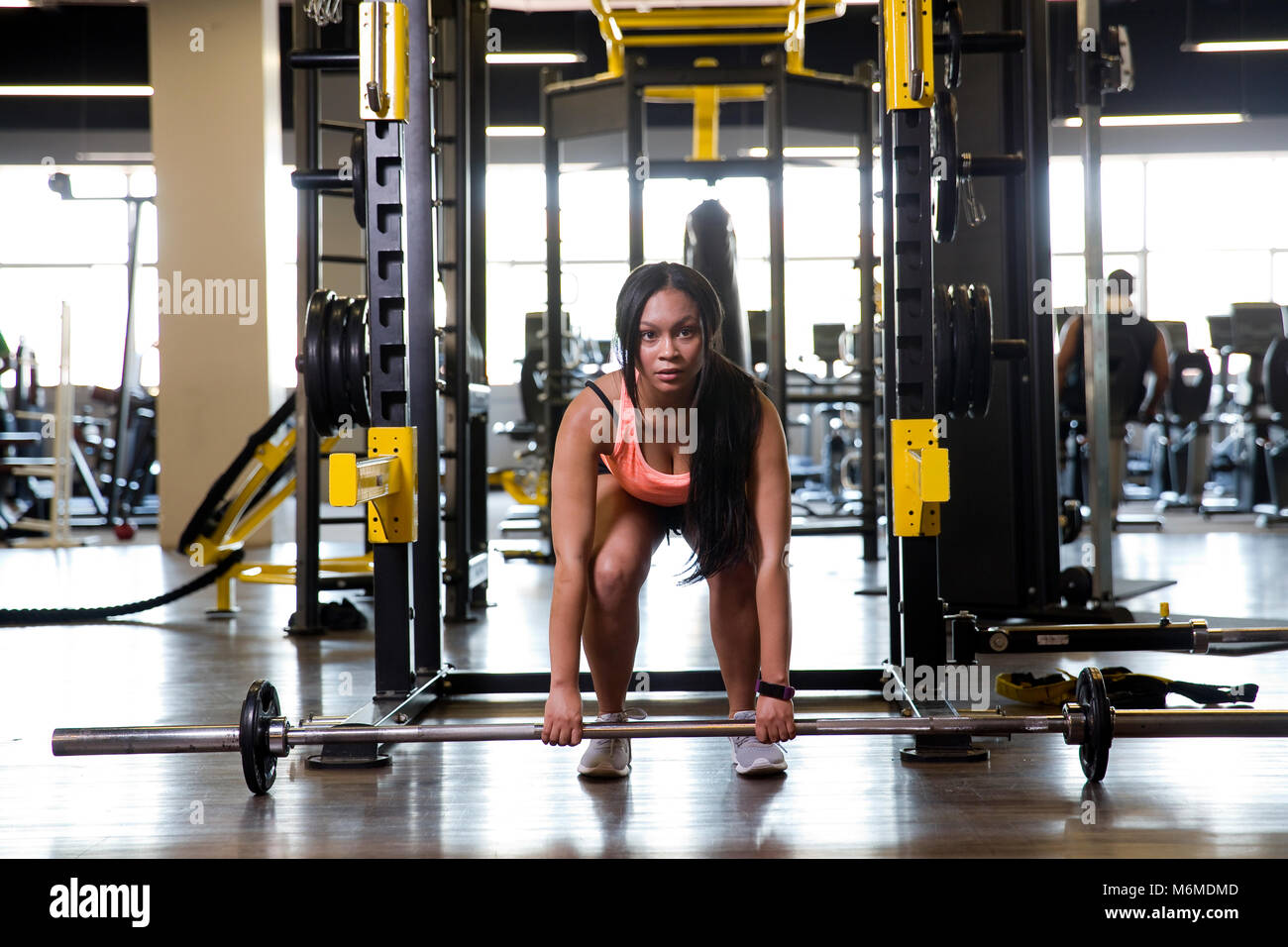 Gemischte Rasse Frau heben Barbell im Gymnasium Stockfoto