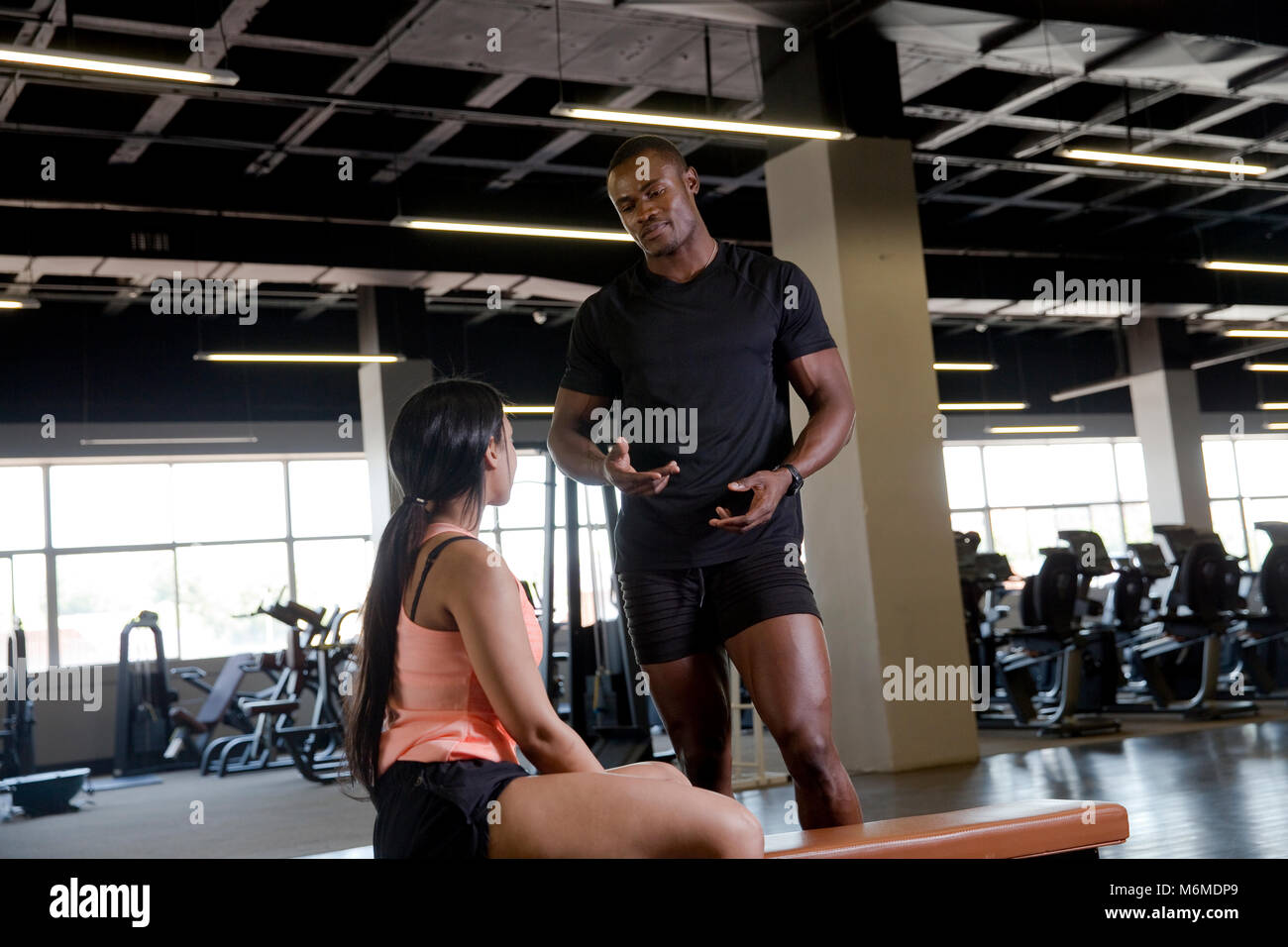 Trainer, die Zusammenarbeit mit Frau im Fitness-Studio Stockfoto