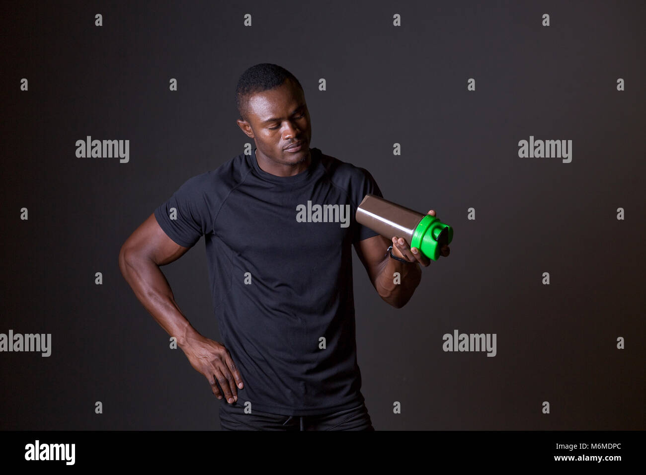 Afrikanischer Mann vorbereitet, seinen Protein Flasche schütteln Stockfoto