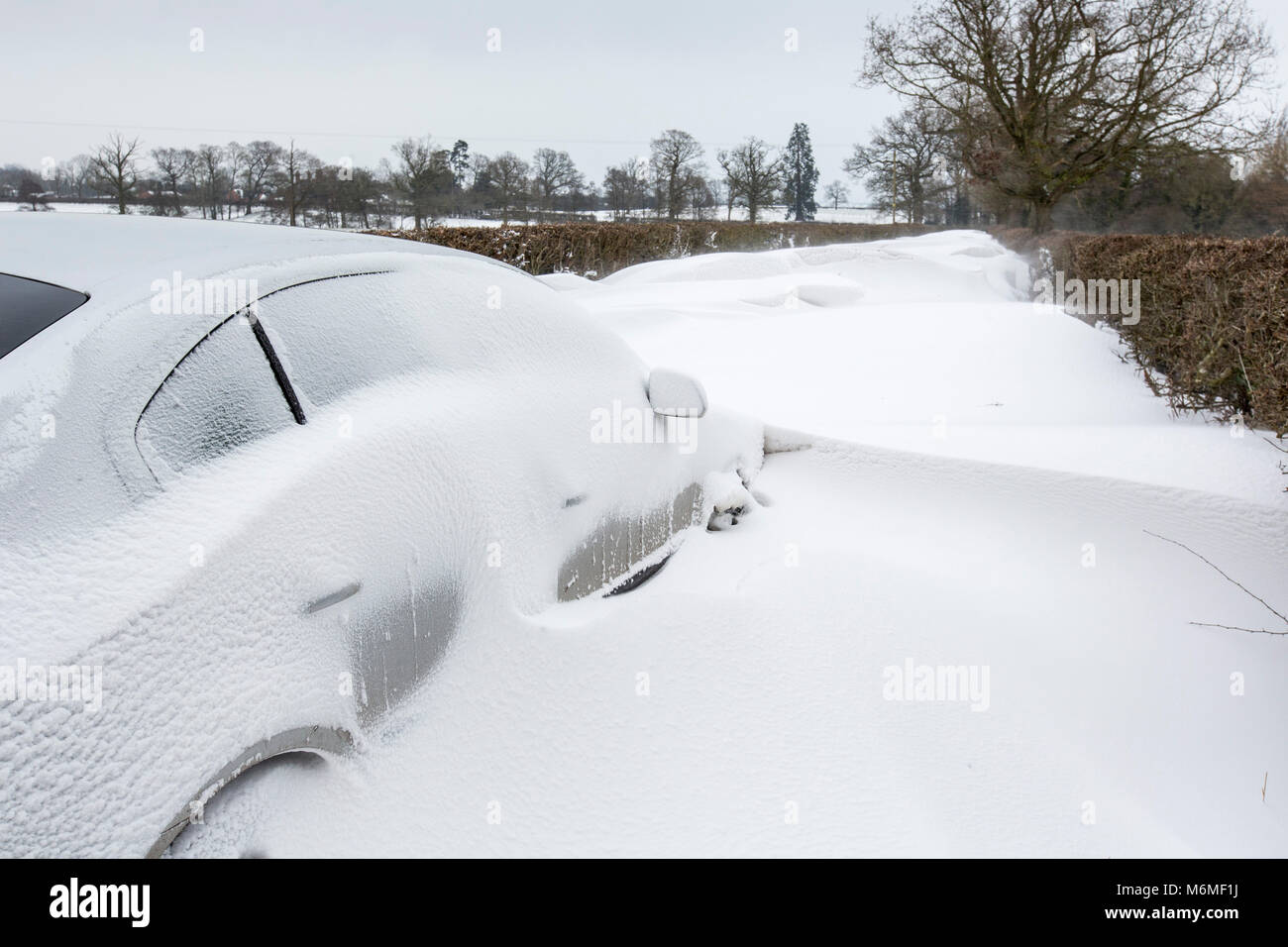 Ein Auto in einem Snow Drift in einem Land Lane in Redditch, Großbritannien klemmt Stockfoto