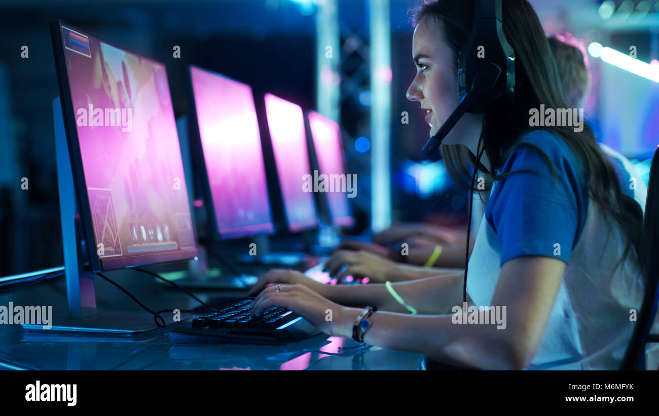 Team von professionellen eSport Gamer Spielen des konkurrierenden MMORPG/Strategie Spiel auf einem Cyber Games Turnier. Sie sprechen miteinander mit Headset Stockfoto