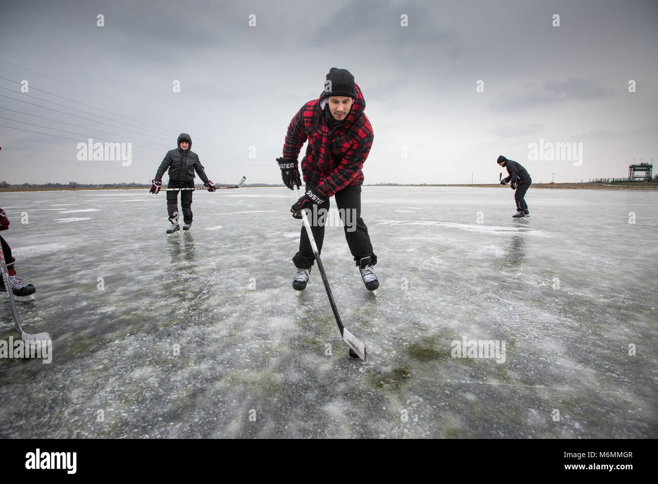 Menschen spielen Eishockey und Eislaufen auf dem Cambridgeshire Fens in der Nähe von Peterborough am Freitag morgen März 2. Nachdem die überfluteten Felder auf die aktuelle Kälte erstarrte, sein, das erste mal seit 6 Jahren den Fens über eingefroren haben. Skater, die sich scharen, um die gefrorene Cambridgeshire Fens heute (Freitag) Nach dem Tier aus dem Osten gab Ihnen die seltene Gelegenheit, den antiken Sport zum ersten Mal in sechs Jahren zu genießen. Flache Gewässer in der Niedermoore in eine riesige Natureisbahn gedreht worden und ist heute ein Paradies für Skater. Skater Stockfoto