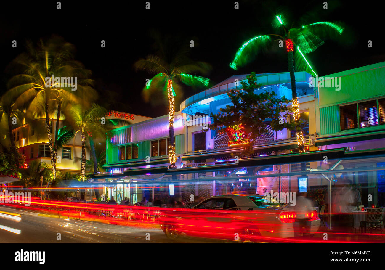 Ocean Drive in Miami in der Nacht mit lebhaften Straße Farben. Autos vorbei durch Erstellen von Linien aus Licht während der langen Belichtungszeit. Palmen, hotel im Hintergrund. Stockfoto