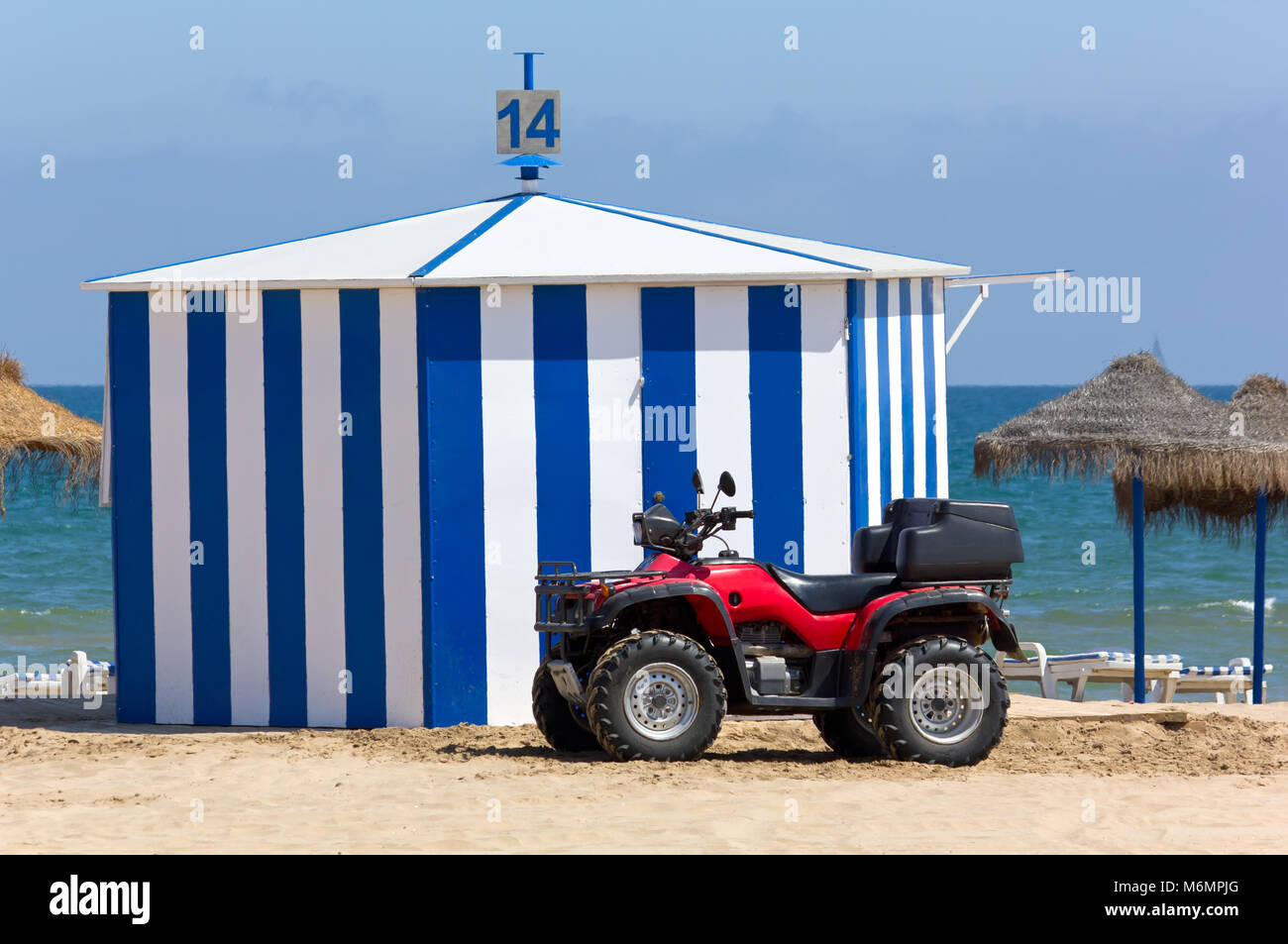 Einen roten vierrädrigen Strand Fahrzeug vor der Hütte an einem Sandstrand Stockfoto