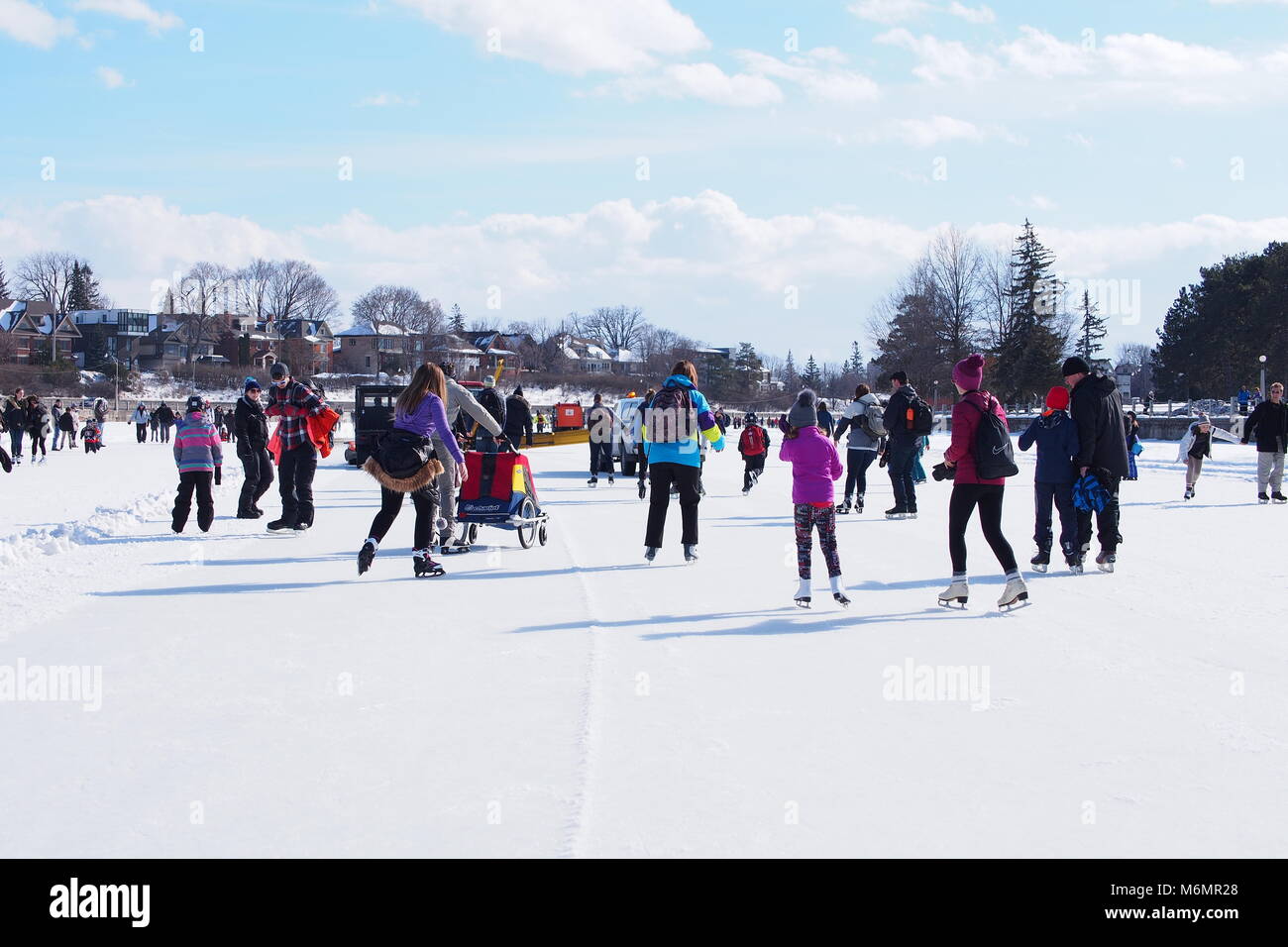 Menschen Schlittschuhlaufen auf einem hellen, sonnigen Tag während Winterlude auf einem gefrorenen Rideau-Kanal-Eislaufbahn, Ottawa, Ontario, Kanada. Stockfoto