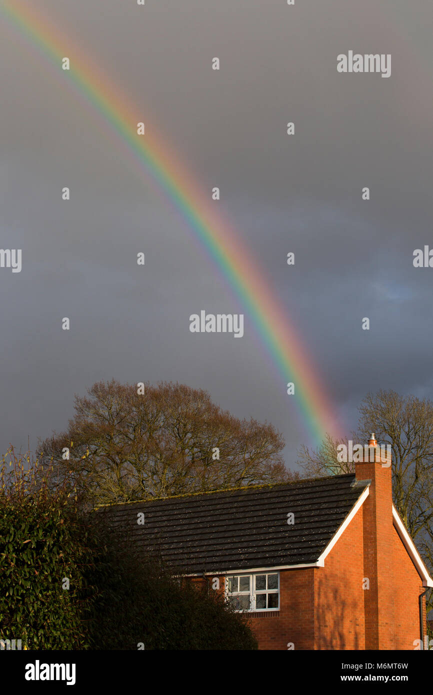 Ein Regenbogen über ein modernes Haus in Großbritannien Stockfoto