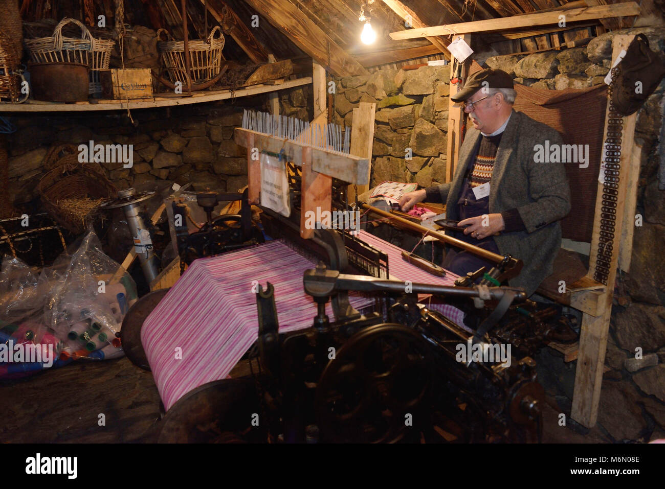 Vereinigtes Königreich, Schottland, Äußere Hebriden, Lewis und Harris, Isle of Lewis. Lewis Loom Zentrum in Stonrnoway. Tweed Weaver vor seinem Webstuhl Stockfoto