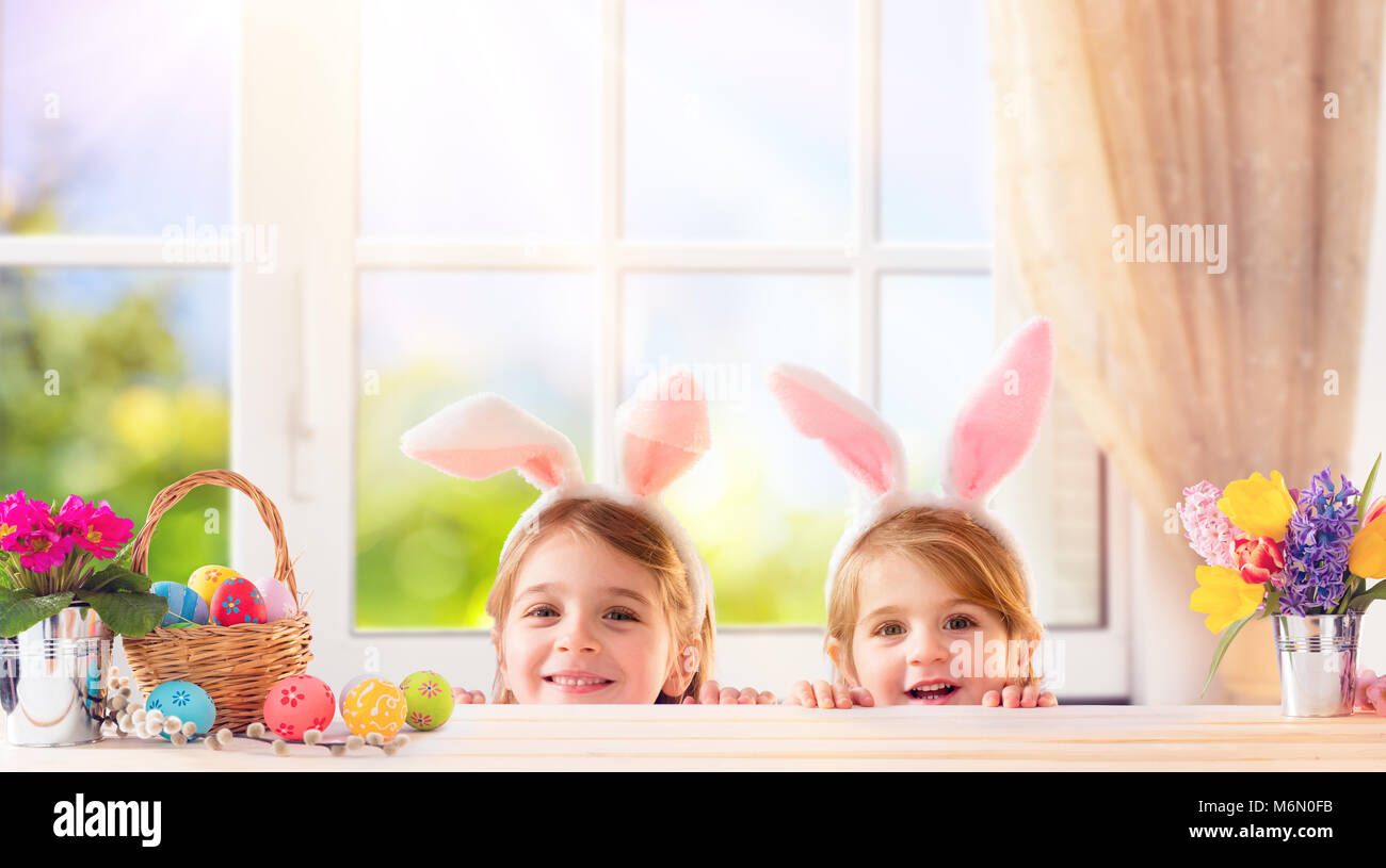 Lustige Kinder mit Hasenohren Spielen zu Hause Stockfoto