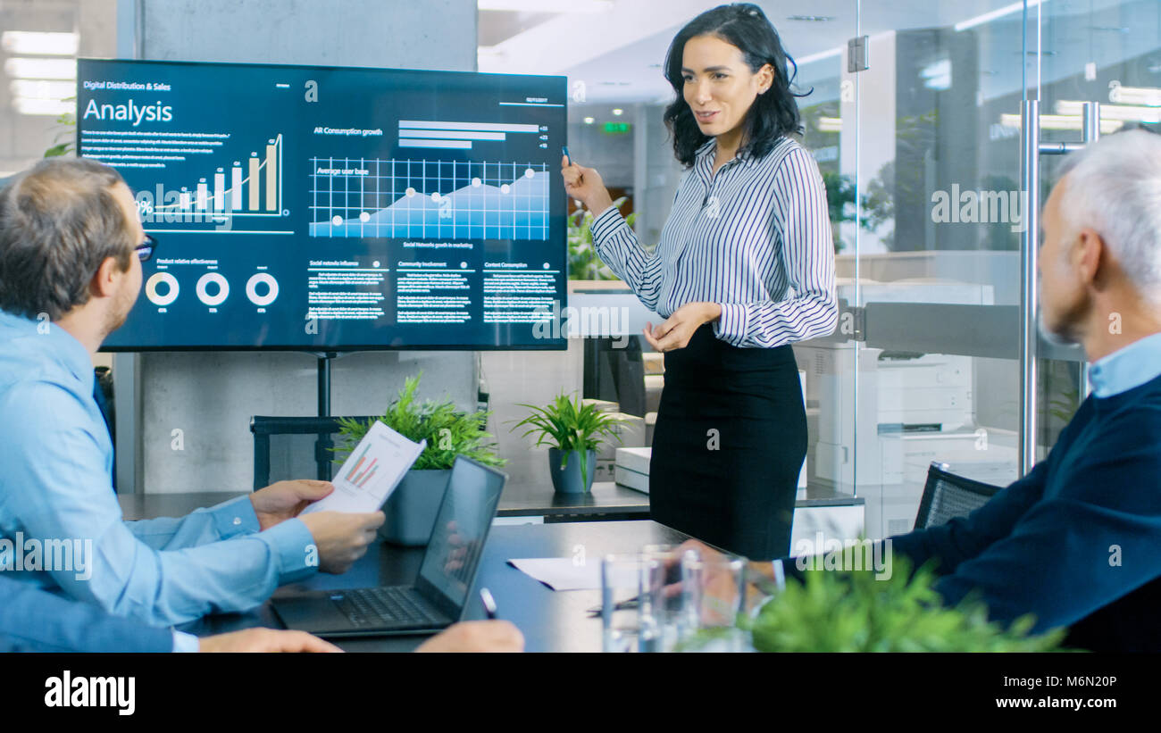 Schöne Geschäftsfrau gibt Bericht/Präsentation zu Ihren Kollegen im Konferenzraum, Sie zeigt Grafiken, Kreisdiagramme und Diagramme Stockfoto