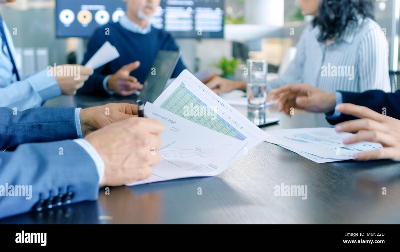 Besetzt Konferenzraum Geschäftsleute am großen Tisch saßen und Freigeben von Dokumenten und Informationen auf dem Laptop. Stockfoto