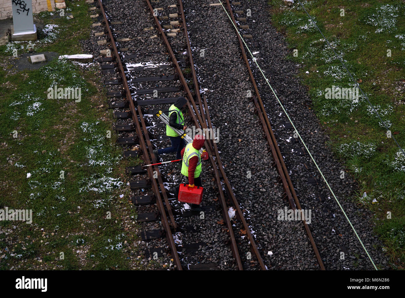 Istanbul, Türkei - 1. März 2018: Zwei Bahnarbeiter oder Ingenieure sind zu Fuß auf den Schienen an Istanbul, Kadiköy. Sie sind bei der Durchführung von Ausrüstungen. Stockfoto