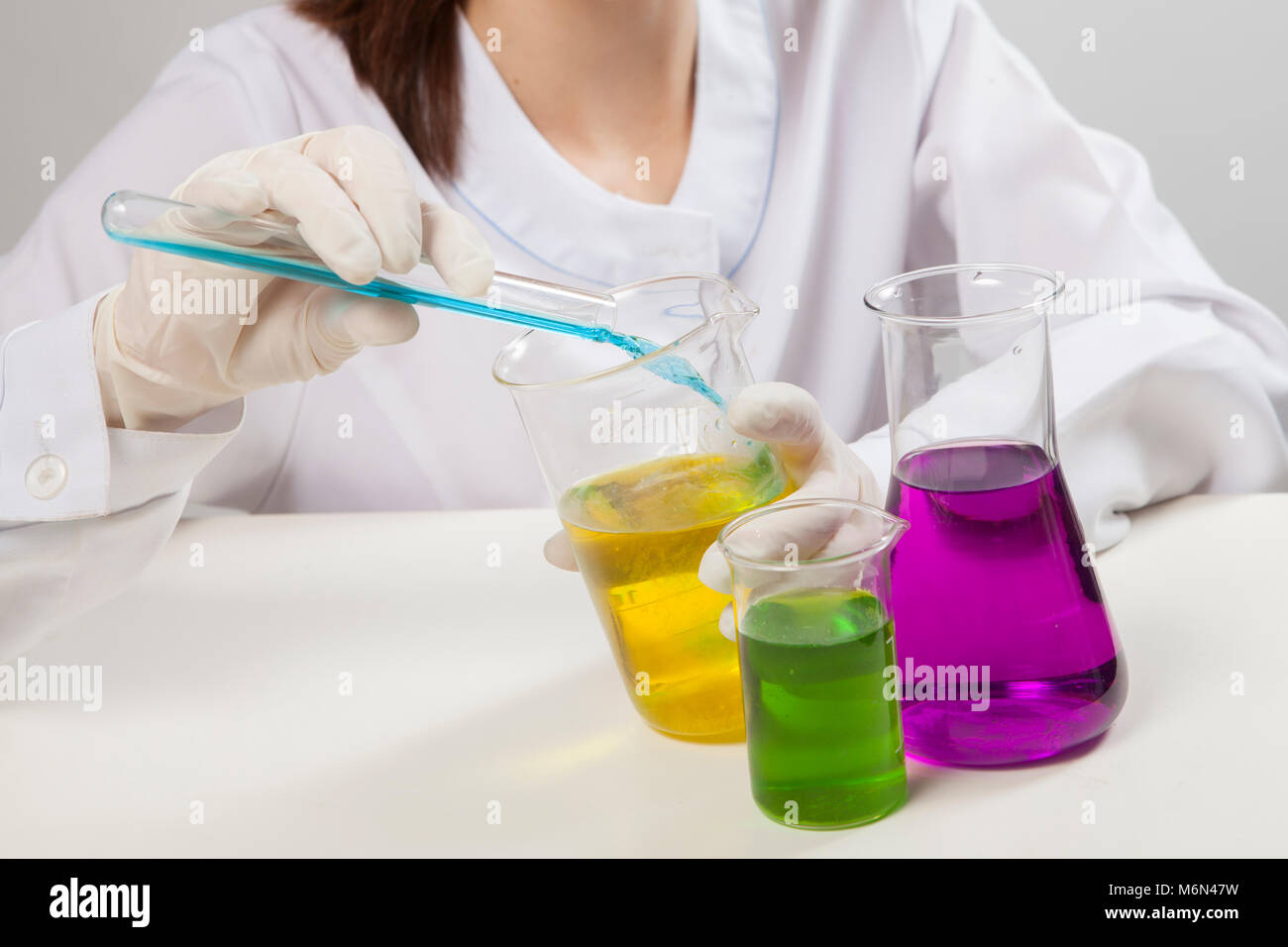 Junge Frau mit Brille und Handschuhe, chemischen Test im Labor. Studio gedreht. Stockfoto