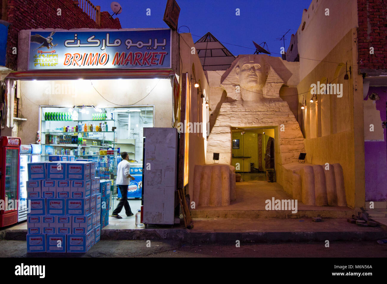 Hotel mit großen Gizeh Sphinx Replik Fassade neben dem Lebensmittelgeschäft im Roten Meer Stadt Dahab, South Sinai, Ägypten Stockfoto