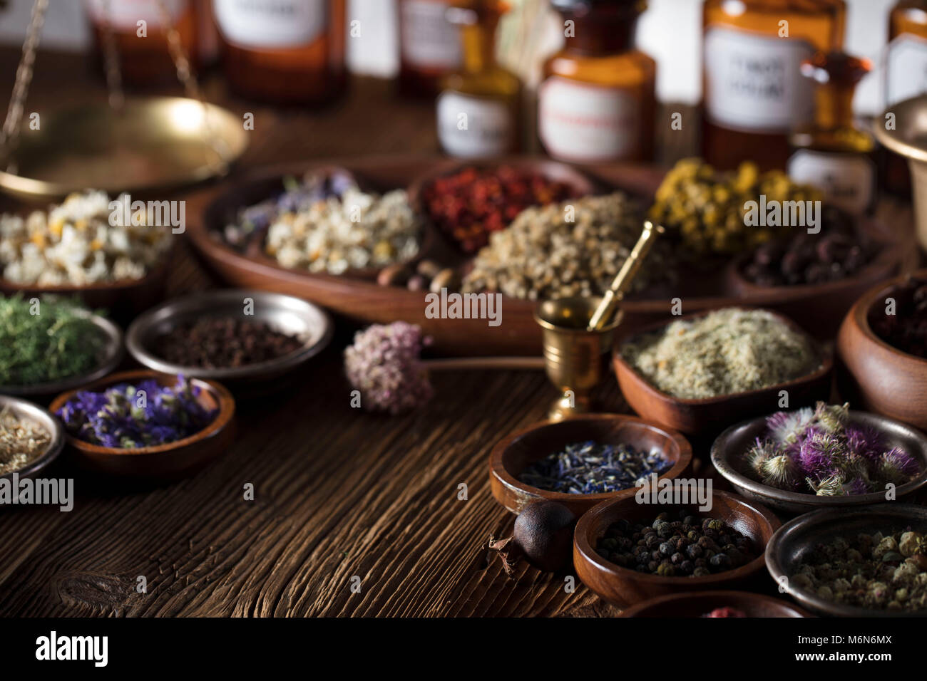 Alternative Medizin. Kräuter in Schalen, Mörtel und Medizin Flaschen auf Holz- rustikalen Tisch. Stockfoto