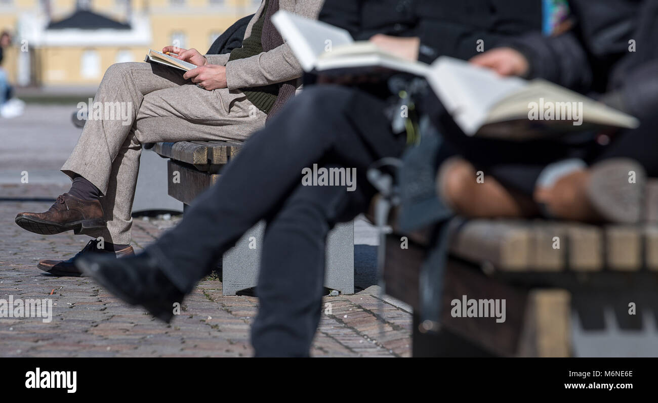 05 März 2018, Deutschland, Karlsruhe: Fußgänger Bücher lesen in der Sonne. Temperaturen bis zu 14 Grad und viel Sonne, erwecken den Eindruck von Frühling. Foto: Sebastian Gollnow/dpa Stockfoto