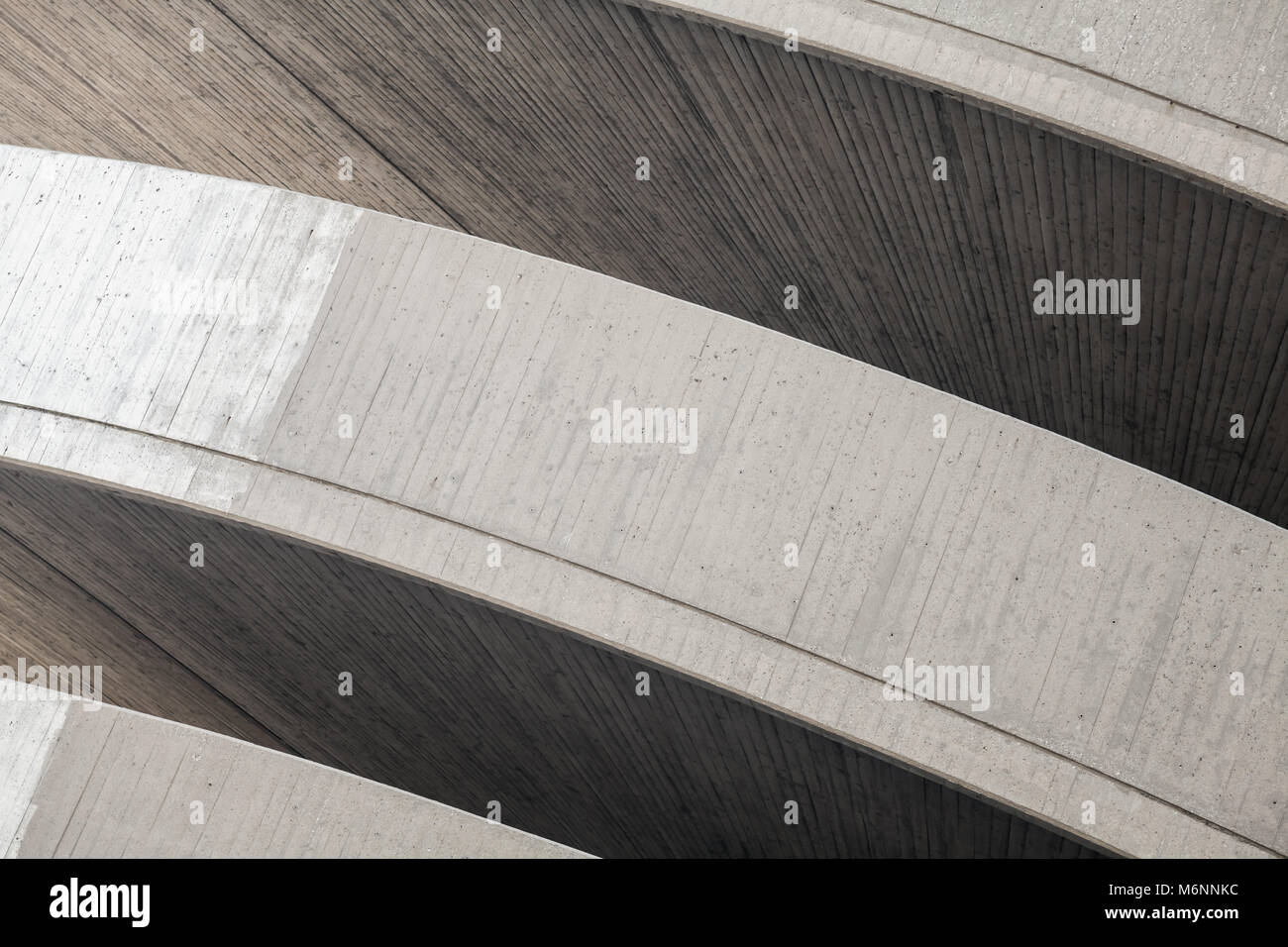 Abstrakte zeitgenössische Architektur Hintergrund. Runde konkrete äußere Fragment mit dunklen Nischen Stockfoto