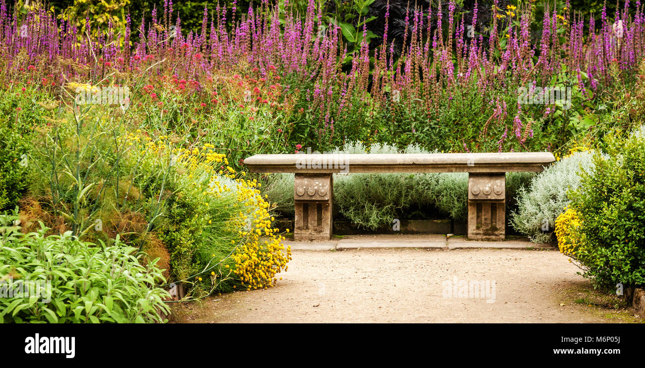 Steinbank in der überschwänglich gepflanzt Küche Garten von Hardwick Hall in Derbyshire UK Stockfoto