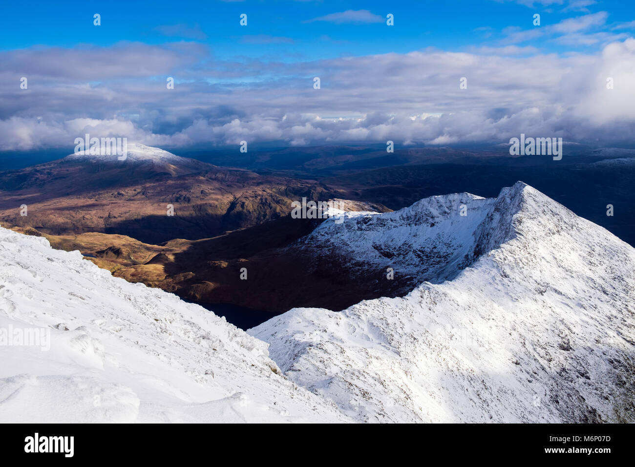 Hohe Aussicht auf Y Lliwedd in Snowdon Horseshoe aus South Ridge im Winter Schnee in Snowdonia National Park. Die schneebedeckten Moel Siabod in Distanz. Wales UK Stockfoto