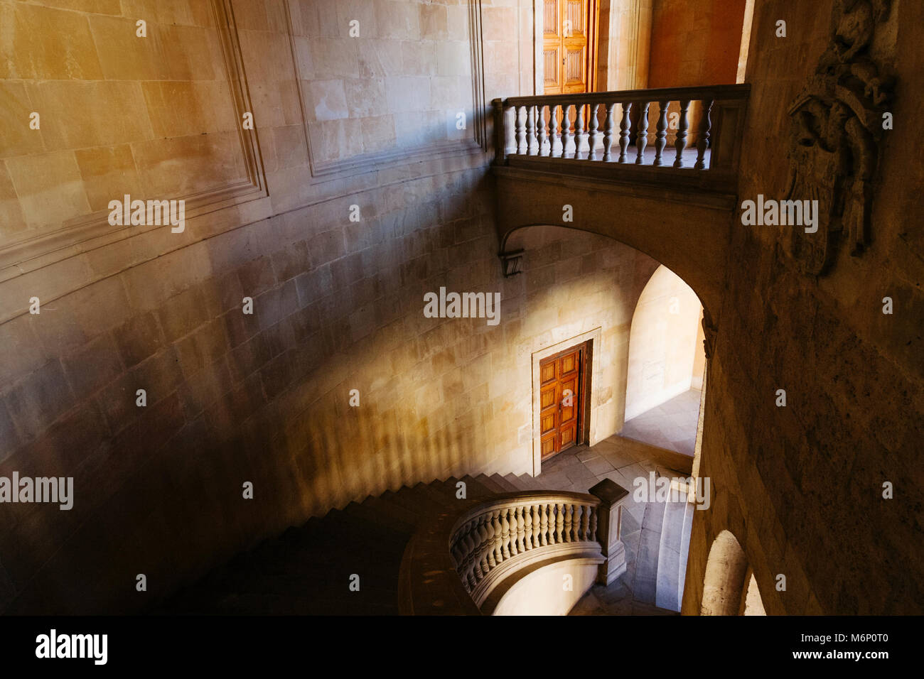 Granada, Andalusien, Spanien: Licht und Schatten Effekt auf den runden Stein Treppe im Inneren der Renaissance Palast von Karl V. (1527). Die struktur Stockfoto