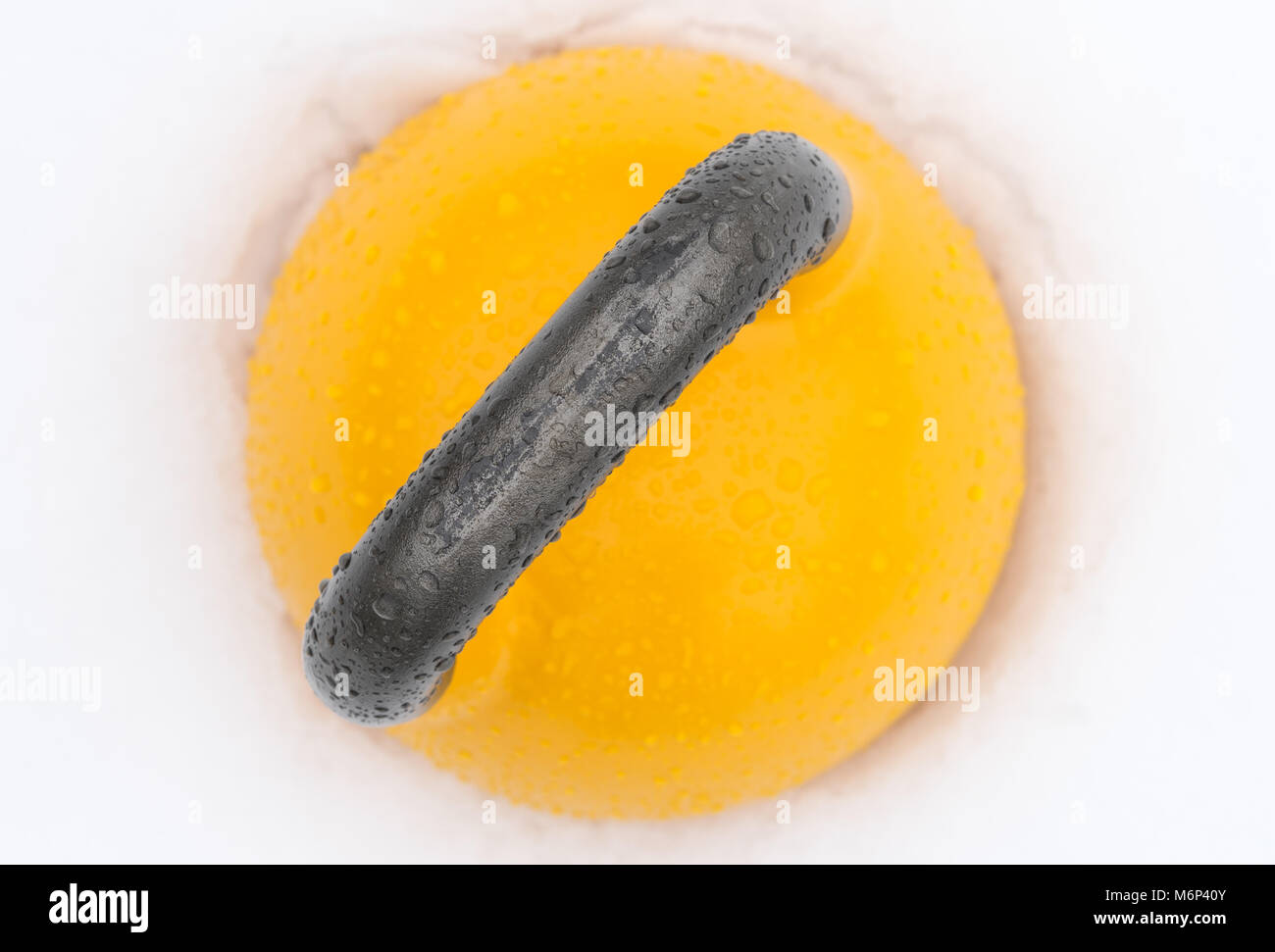 Blick von oben auf ein gelbes Wettbewerb kettlebell draußen im Schnee. Stockfoto