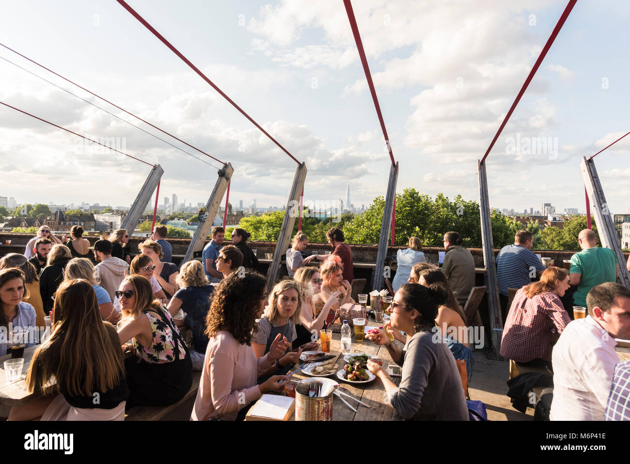 Junge Menschen Geselligkeit und einen Drink zu genießen an Franks Cafe Bar und Restaurant auf der Dachterrasse mit Blick über die Stadt. Stockfoto