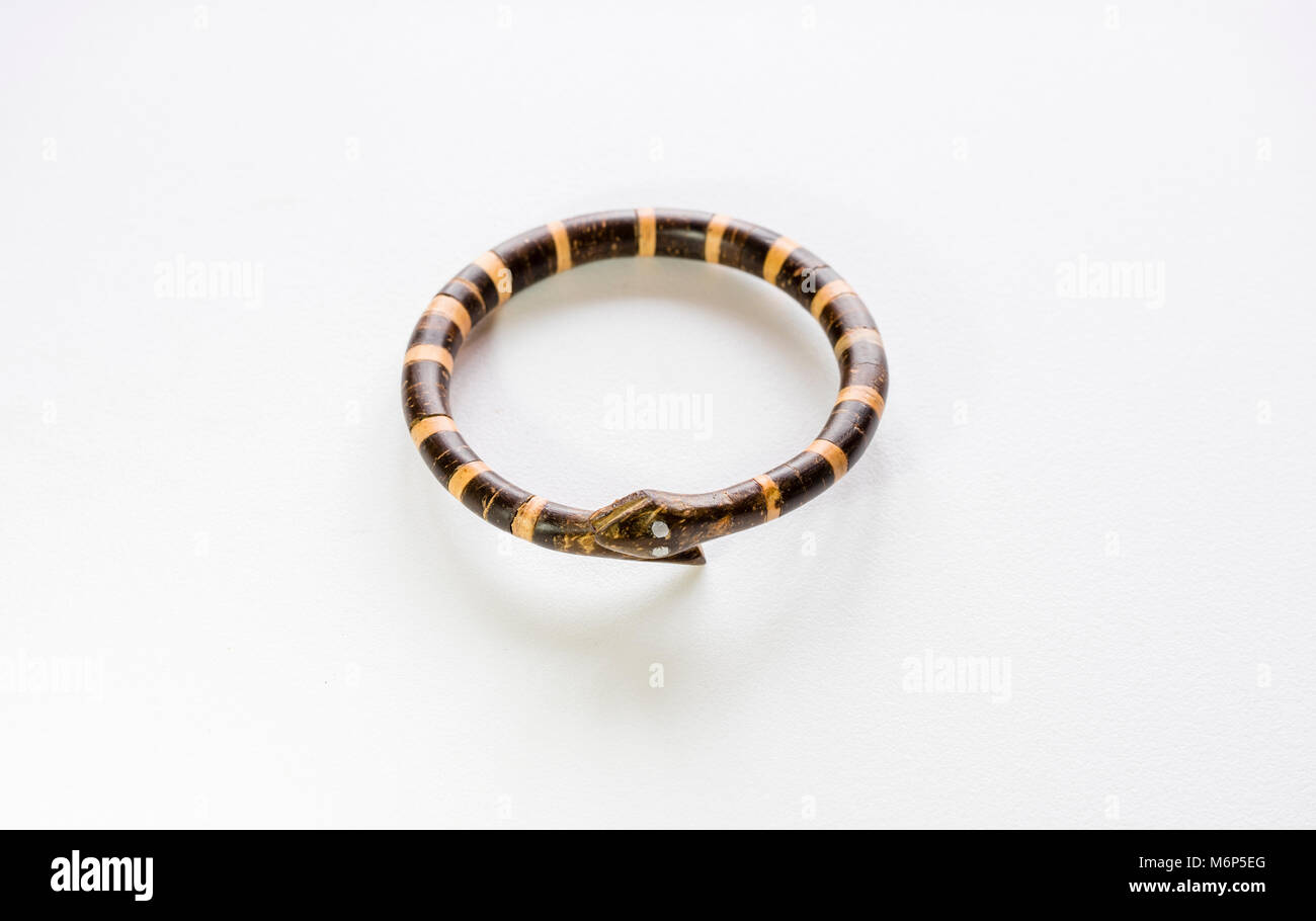 Indonesische Holz gestaltete und handgefertigte Armband in der Form von zwei Schlangen auf weißem Hintergrund Stockfoto