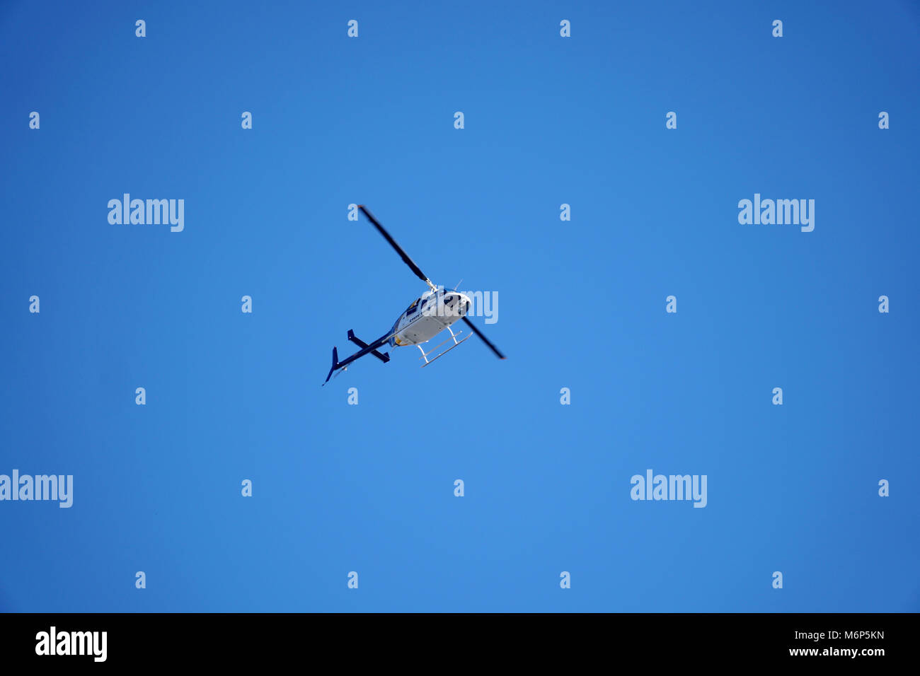 Staatliche Polizei schwebenden Hubschrauber Overhead die Antenne Unterstützung für gesetzdurchführungpersonal Boden Stockfoto