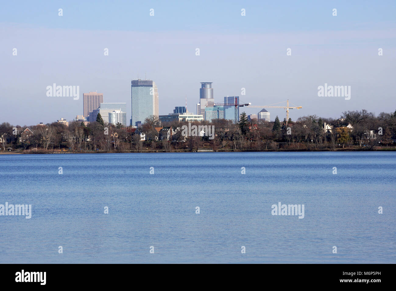 Minneapolis Minnesota Skyline. Breite zur Gründung foto Wolkenkratzer Turm über der Baumgrenze und schönen blauen See im Winter. Gebäude der Innenstadt financia Stockfoto