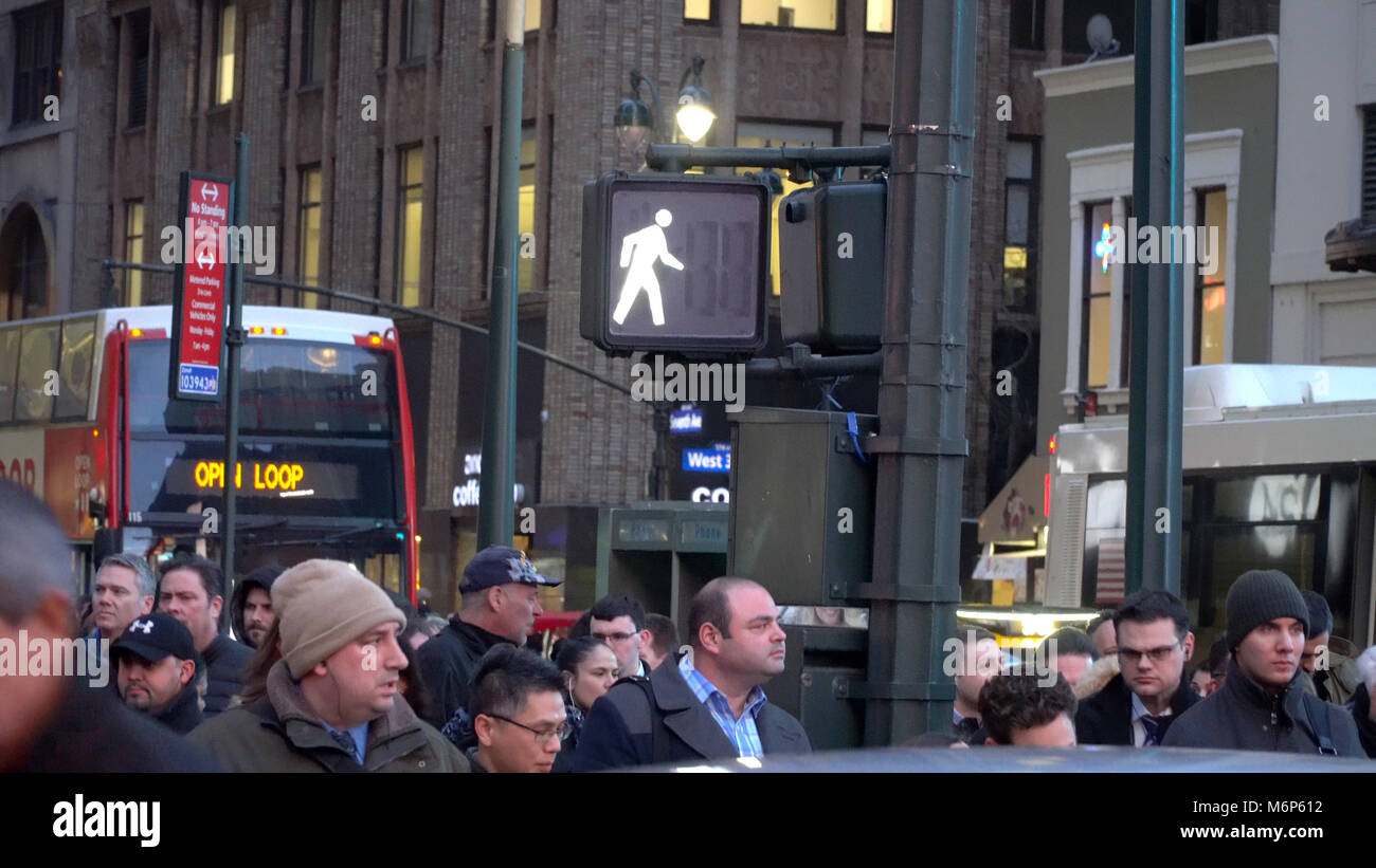 New York City - ca. 2017: Beleuchtete gehen Sie zu Fuß Symbol auf street lamp Pol in Midtown Manhattan während der Rush Hour. Pendler warten für den Autoverkehr Stockfoto