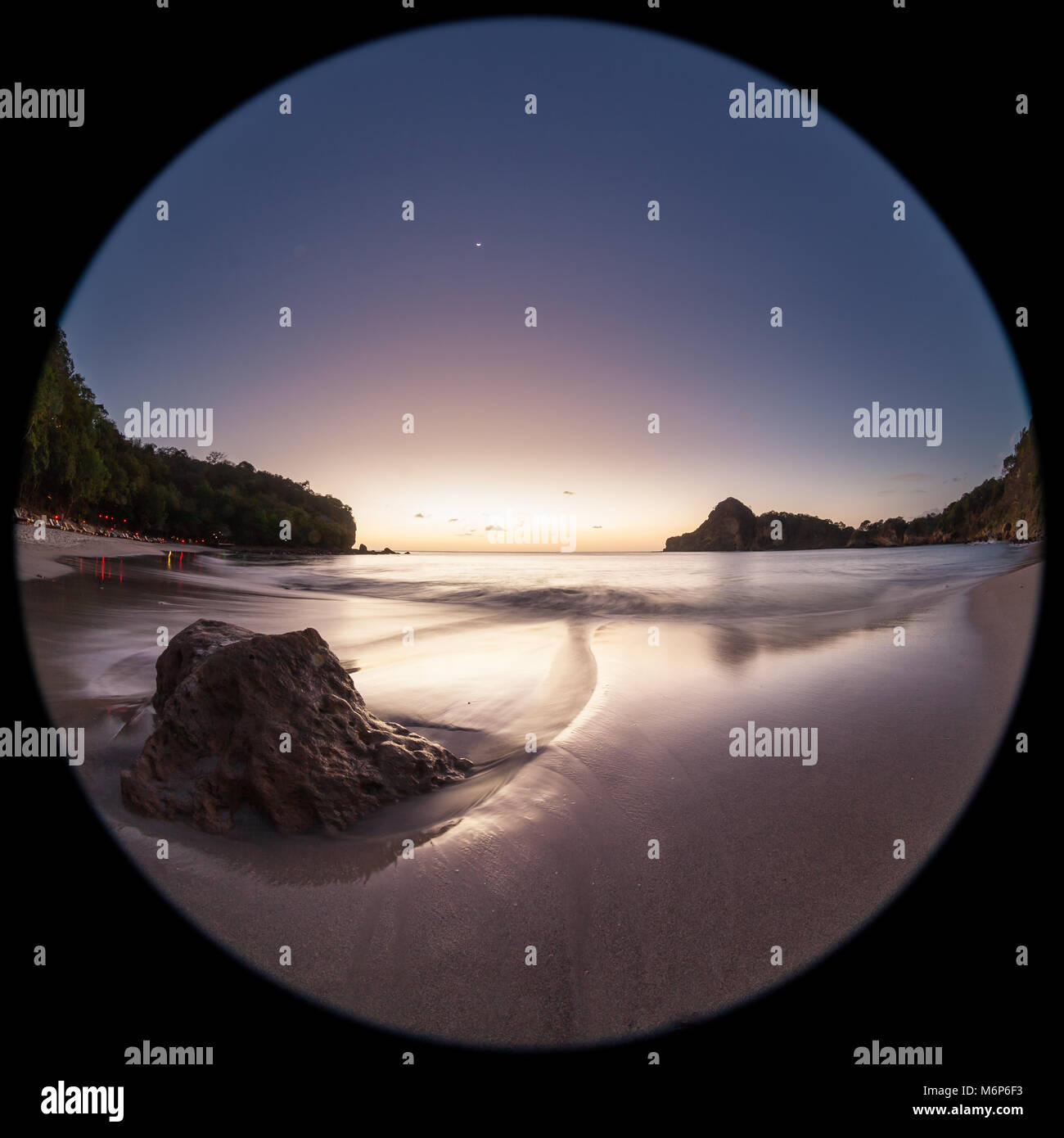 Entspannende beach Szene mit einem Fish Eye Objektiv erzeugen Kreisförmige Super Wide Angle View bei Sonnenuntergang mit hellen blauen Himmel Stockfoto