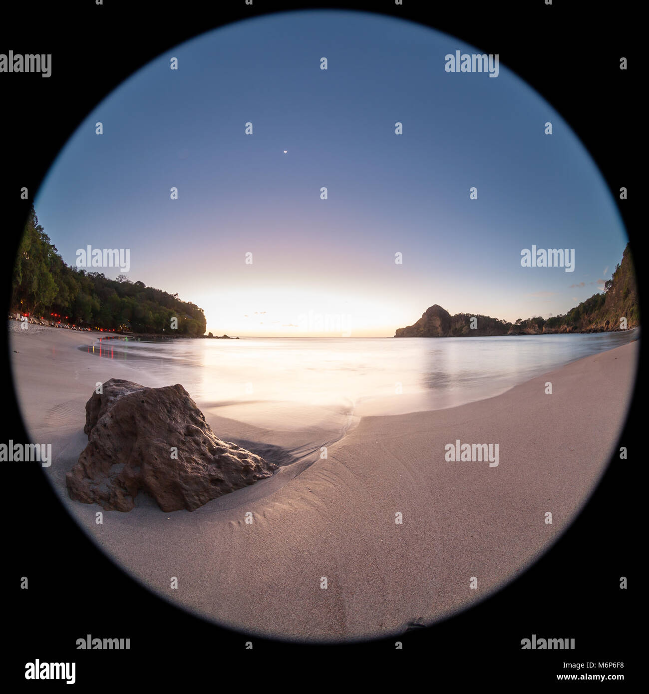 Entspannende beach Szene mit einem Fish Eye Objektiv erzeugen Kreisförmige Super Wide Angle View bei Sonnenuntergang mit hellen blauen Himmel Stockfoto