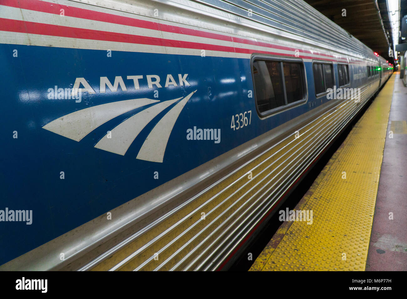 New York City, ca. 2017: Amtrak Bahnhof Penn Station Railroad Terminal Plattform Manhattan. Rot, Weiß und Blau Logo. Lange Distanz business Schiene kom Stockfoto