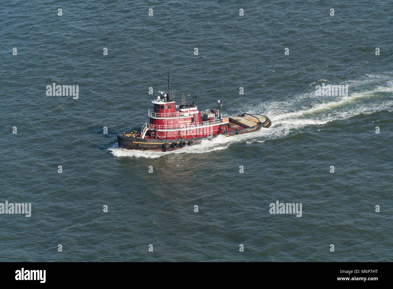 Luftaufnahme eines New York City harbour Tug Boat segeln durch Wasser großen Behälter und Tank Schiffe in den Hafen zu unterstützen. Stockfoto