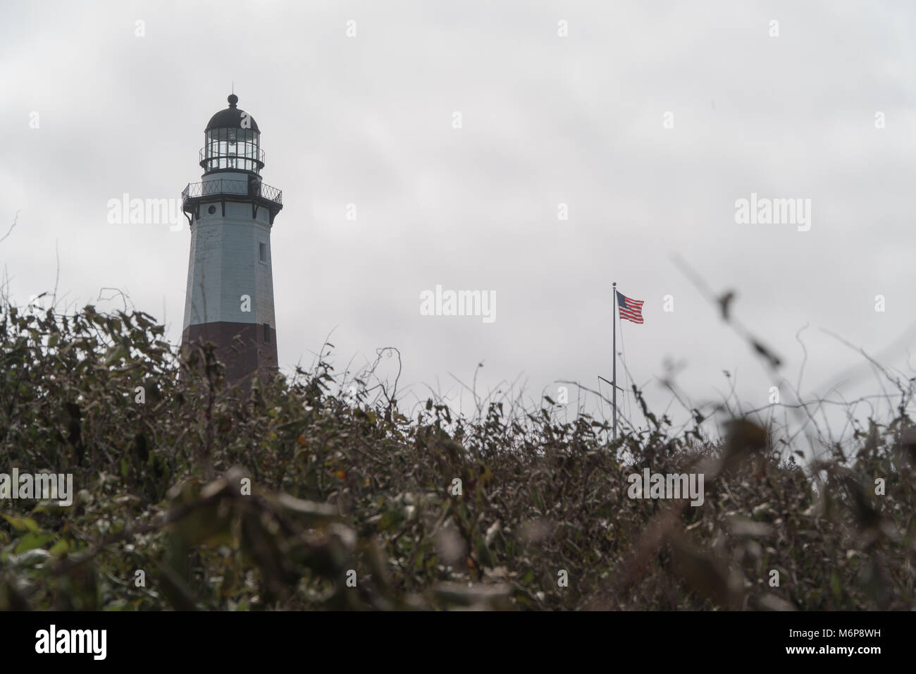 Montauk Point Lighthouse und amerikanische Flagge Ocean Breeze Wind stehen hoch im Herbst Tag. Ende von Long Island State Park Lage das Historische Museum von Mar Stockfoto