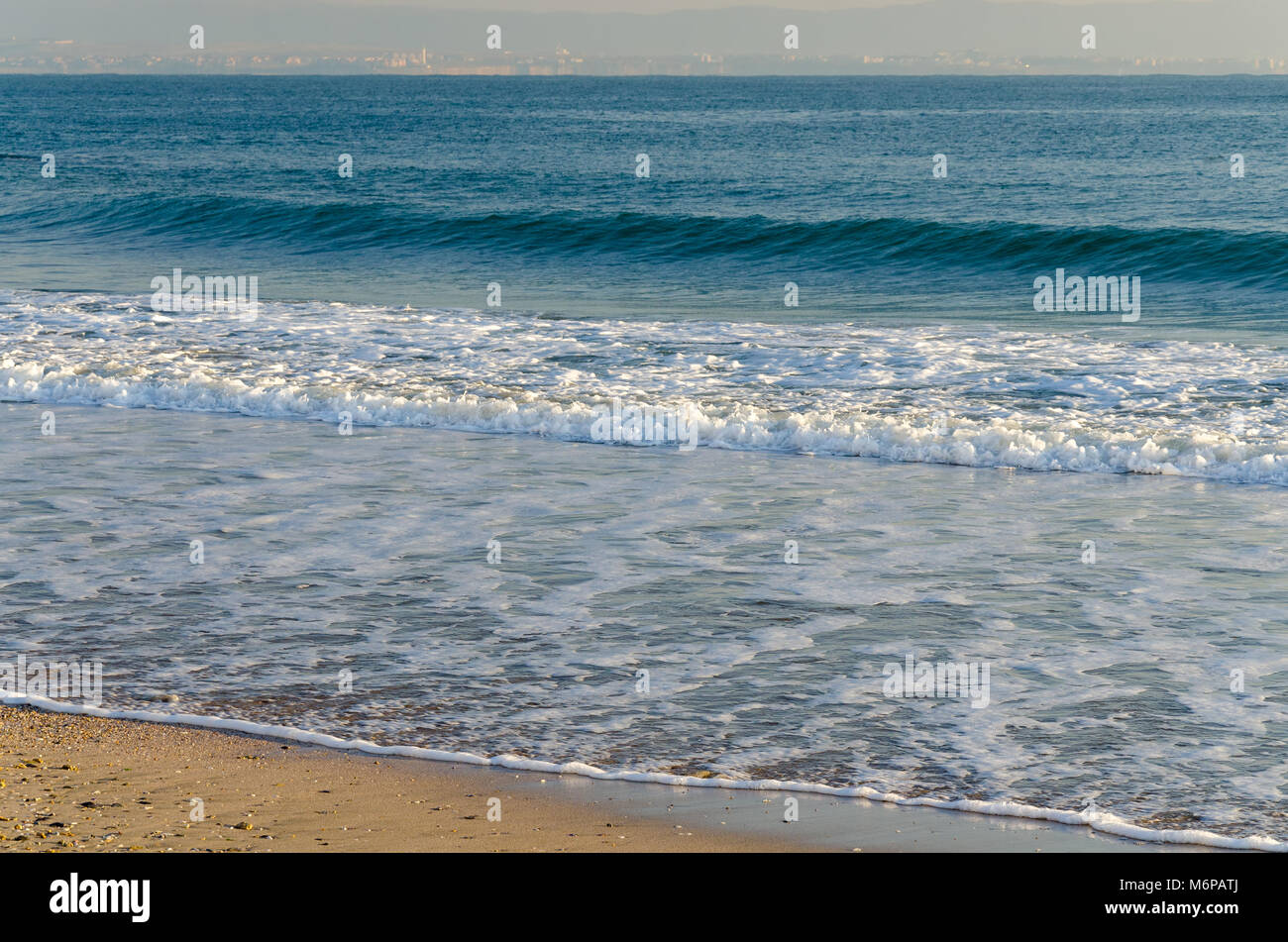 Seascape Hintergrund mit sanften blauen Wellen am Strand mit gelbem Sand Stockfoto