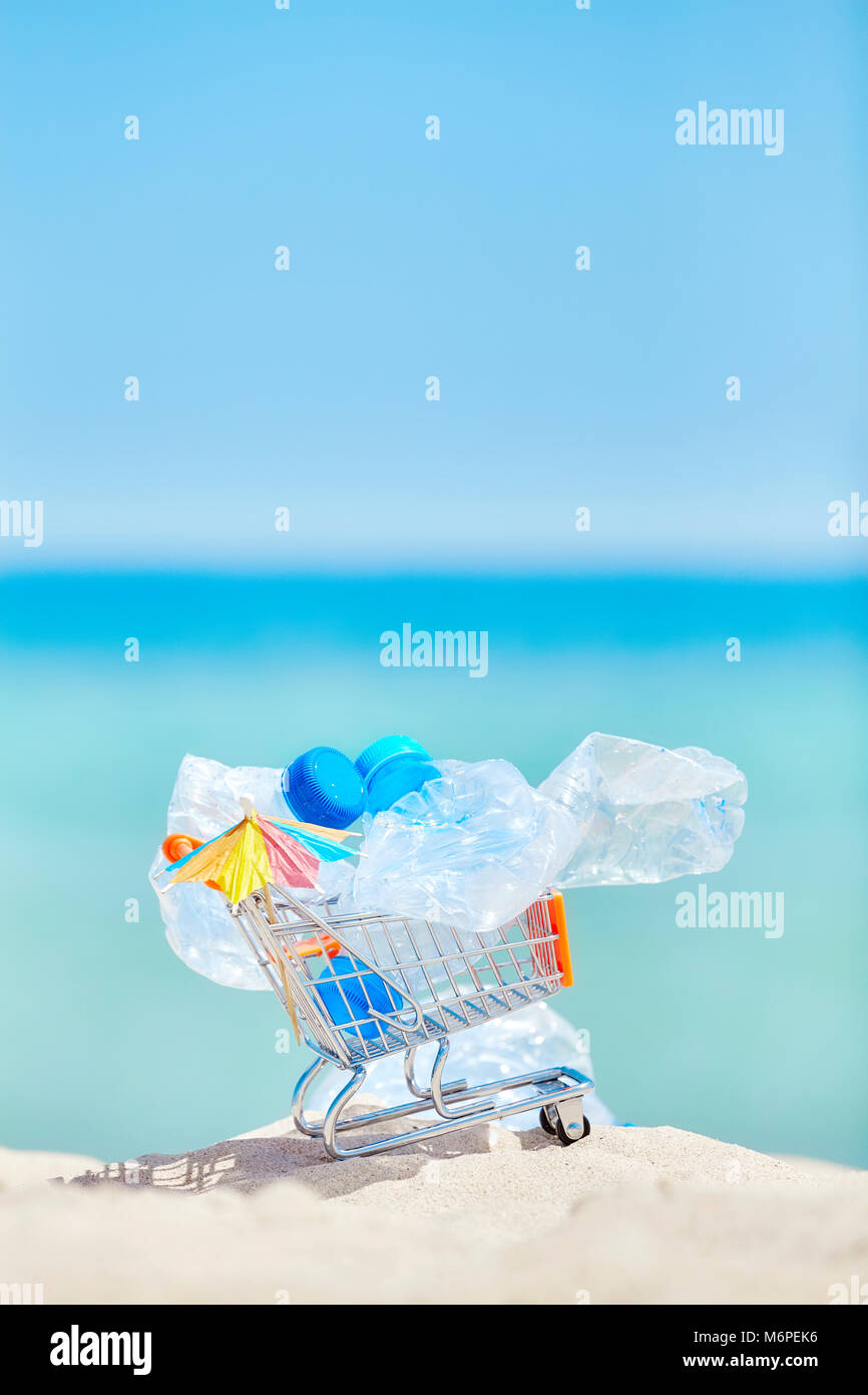 Miniatur-Einkaufswagen mit leeren Plastikflaschen, die Links von Touristen auf einem tropischen Strand, Umweltverschmutzung Konzept Bild, selektiven Fokus. Stockfoto