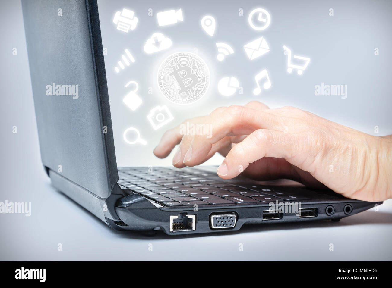 Hände schreiben auf Tastatur mit Bitcoin in den Mittelpunkt der gemeinsamen Medien Symbole. Konzept der wachsenden Verbreitung der digitalen virtuellen cryptocurrency Zahlung Stockfoto