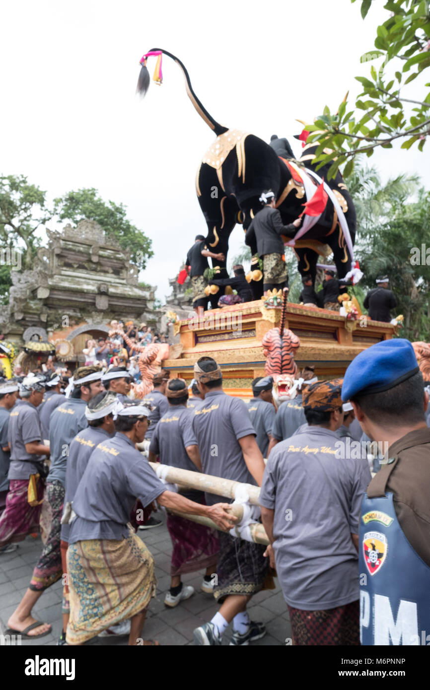 Balinesische Männer tragen die schwere schwarze Sarkophag Stier durch die Straßen von Ubud, Bali für die einäscherung Zeremonie der Königin Niang Agung Stockfoto