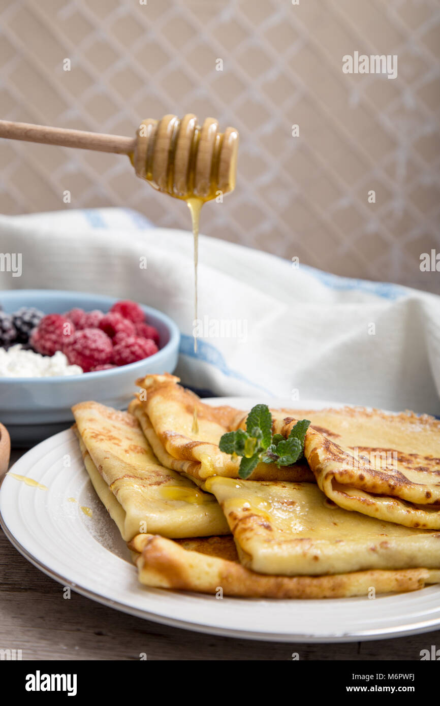 Duftende frische Pfannkuchen mit Ahornsirup und Honig. Russische urlaub Fastnachtswoche. Pfannkuchen mit Honig oder Sirup. Stockfoto