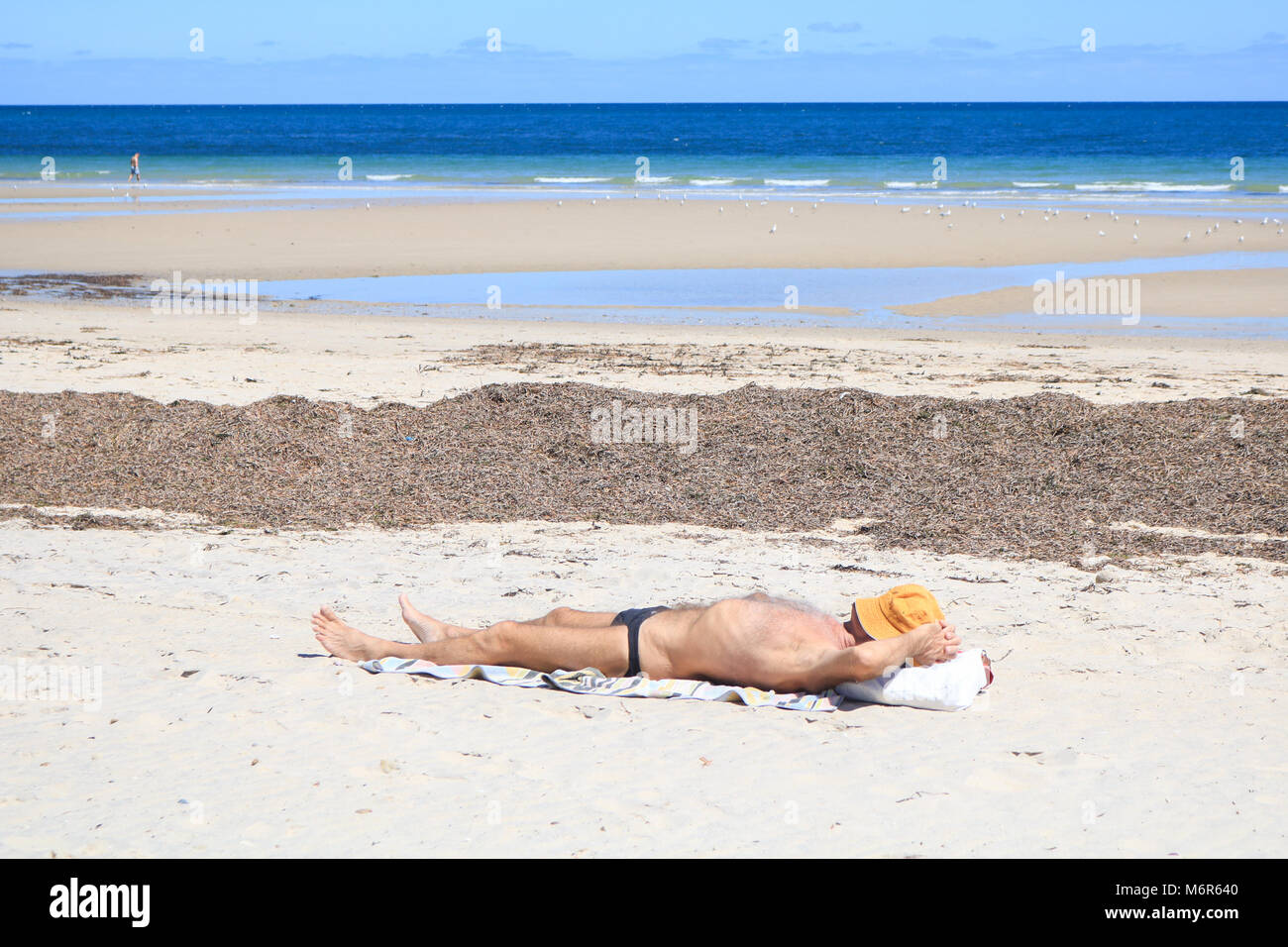 Adelaide Australien. 6. März 2018. Eine beachgoer Neben getrocknetes Seegras angespült am Strand von Glenelg Adelaide an einem heißen Sommertag Credit Sonnen: Amer ghazzal/Alamy leben Nachrichten Stockfoto