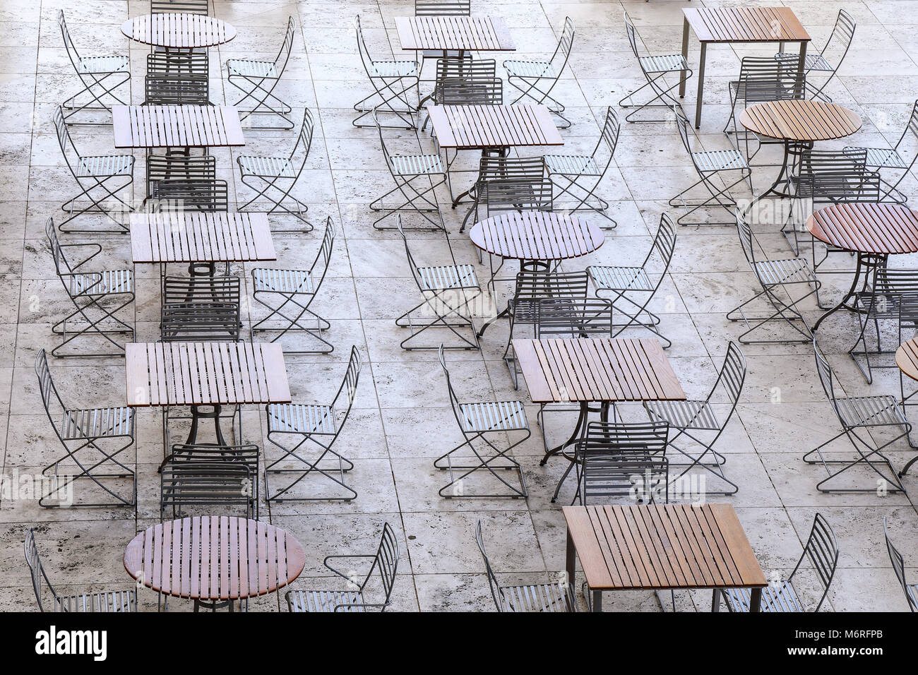 Geometrische Anzeige leerer Tische und Stühle aufgereiht in einer Kantine Stockfoto