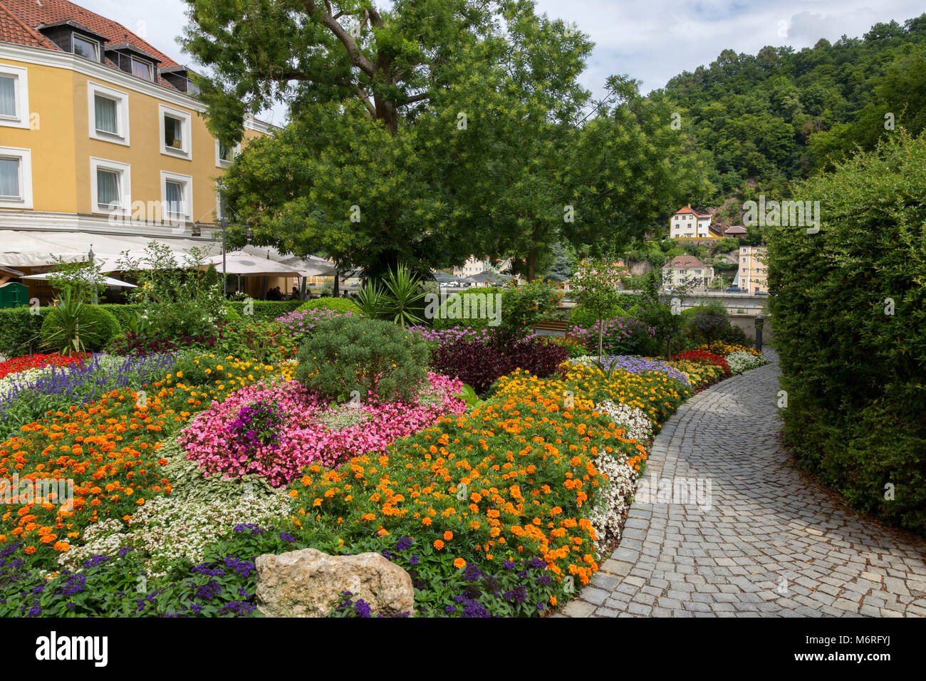 Blumengarten von gepflasterten Gehweg in der charmanten bayerischen Stadt Passau, Deutschland umgeben. Stockfoto