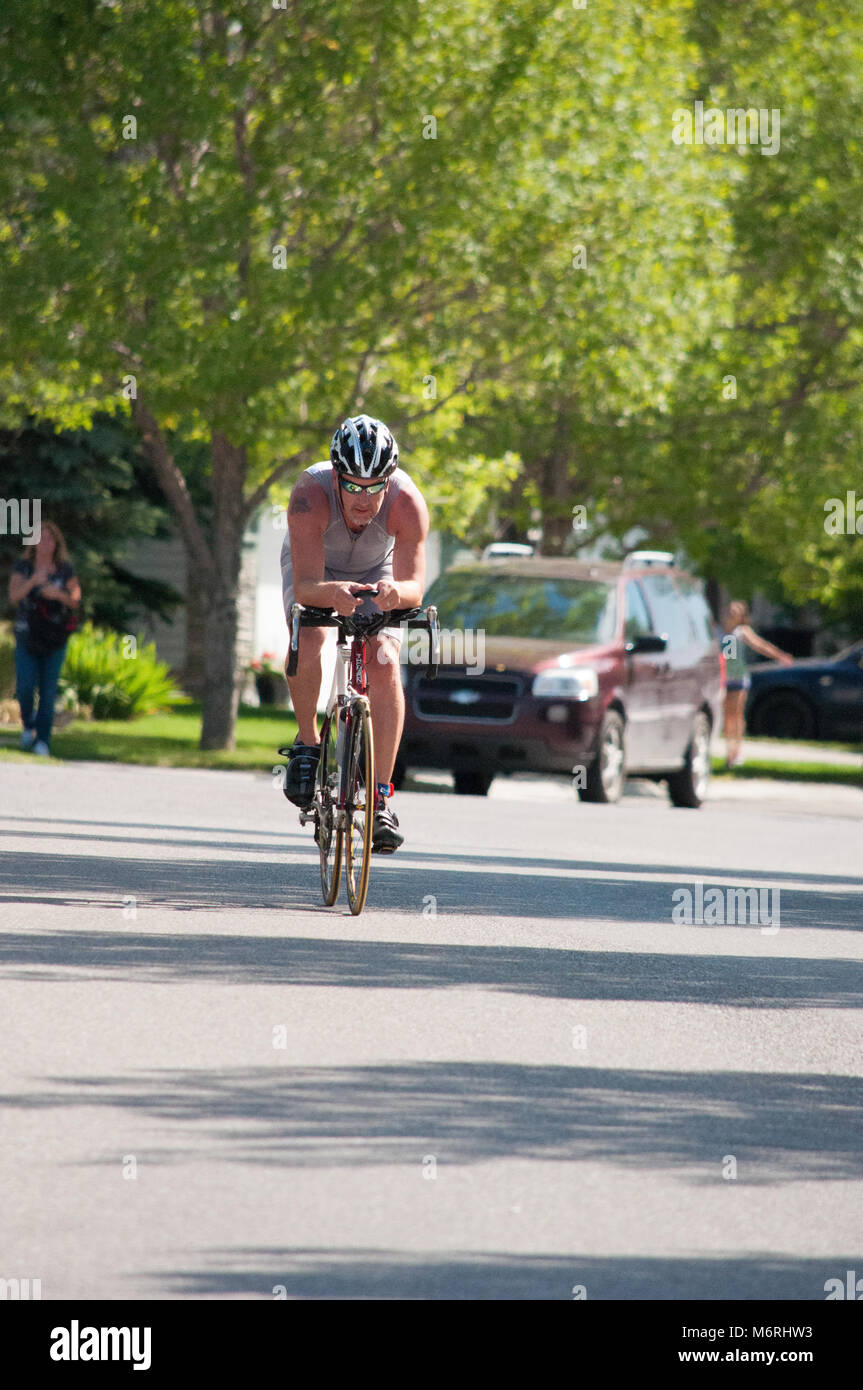 Ein Amateur-Triathlet tritt im Radsport Teil eines lokalen Sprint-Triathlon in der Gemeinde Lake Chapparel, Calgary, Alberta. Stockfoto
