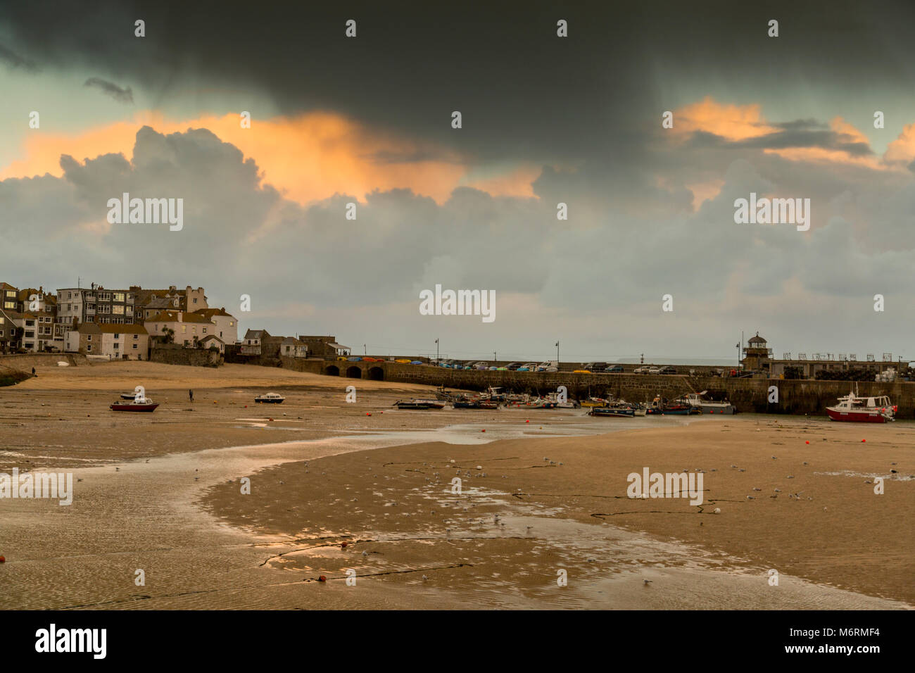 Ebbe und stürmischen Himmel über einem verlassenen Hafen im Winter in St. Ives, Cornwall, England, Großbritannien Stockfoto