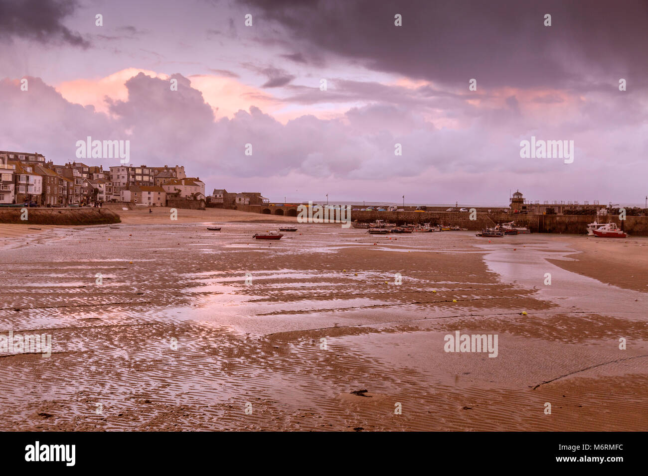 Ebbe und stürmischen Himmel über einem verlassenen Hafen im Winter in St. Ives, Cornwall, England, Großbritannien Stockfoto