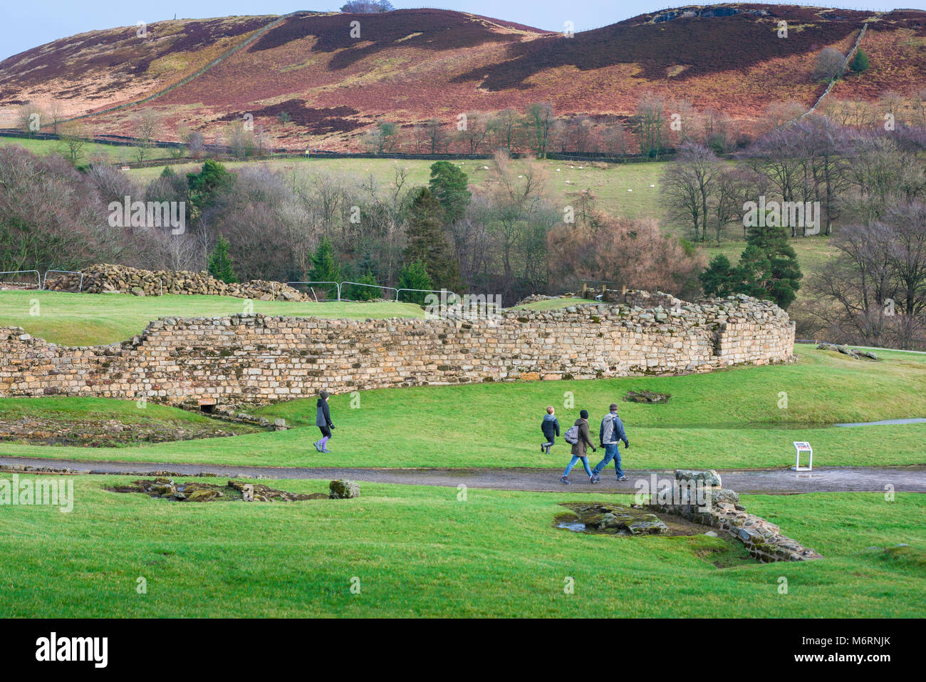 Vindolanda Roman Fort, eine Familie, die in der folgende Website in Northumberland, Spaziergang, vorbei an einer großen römischen Stadtmauer und Wall, England, Großbritannien Stockfoto