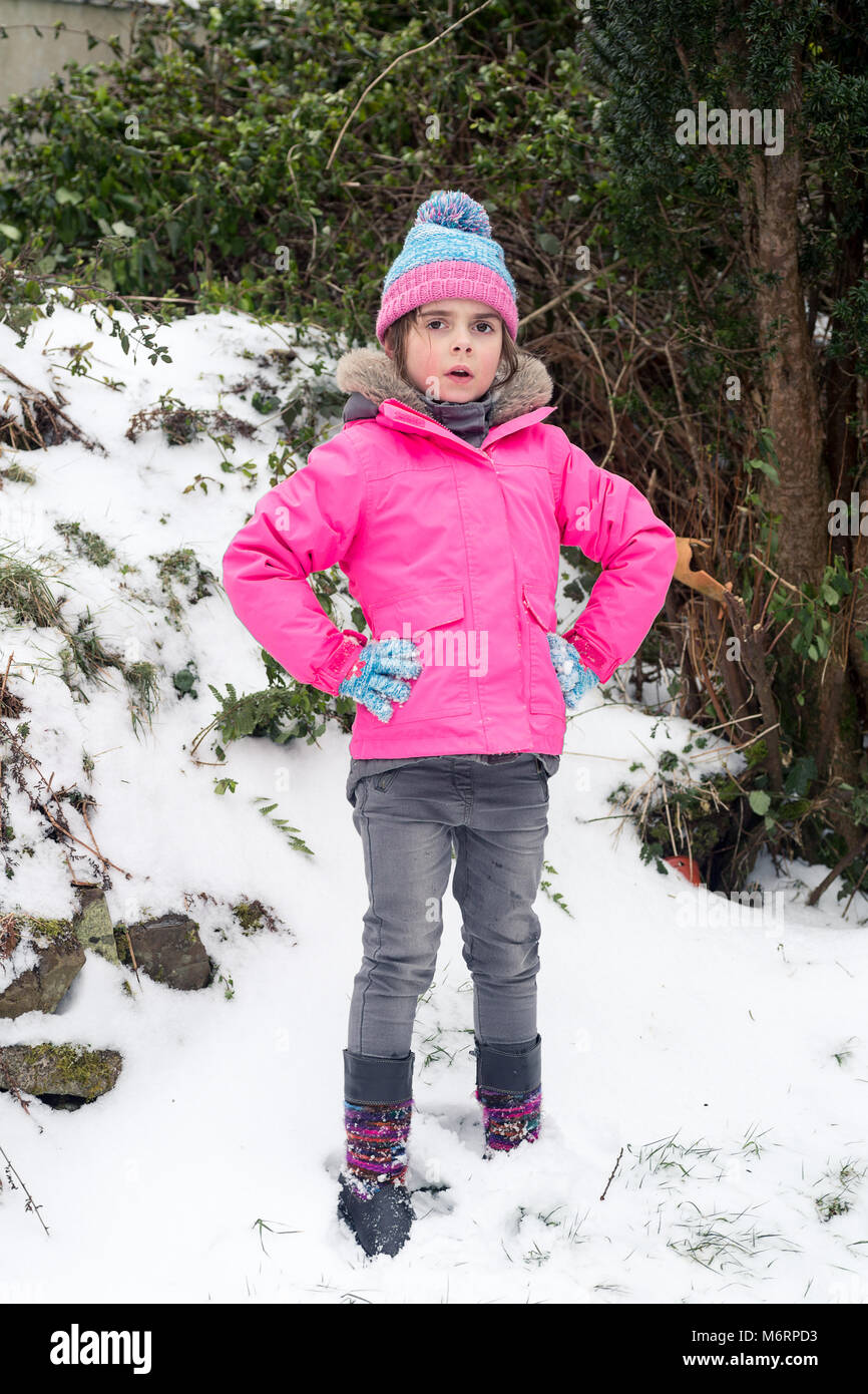 Hübsches kleines stehendes Mädchen im Schnee. Volle Länge vertikale Portrait. Kind 5 oder 6 in schneereichen Winter Wetter im Alter. Stockfoto